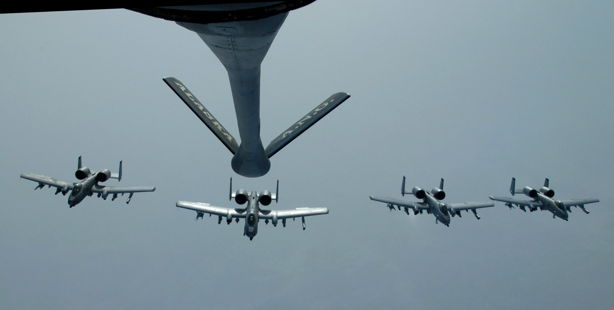 Four A-10 Thunderbolt IIs fly in formation behind a KC-135 Stratotanker April 4 over the Pacific Alaska Range Complex. Nearly all internal fuel, approximately 200,000 pounds, can be pumped through the flying boom, the KC-135's primary fuel transfer method. The A-10s are from the 355th Fighter Squadron, and the KC-135 is from the 168th Air Refueling Squadron, all from Eielson Air Force Base, Alaska. (U.S. Air Force photo/Master Sgt. Robert Wieland) 
