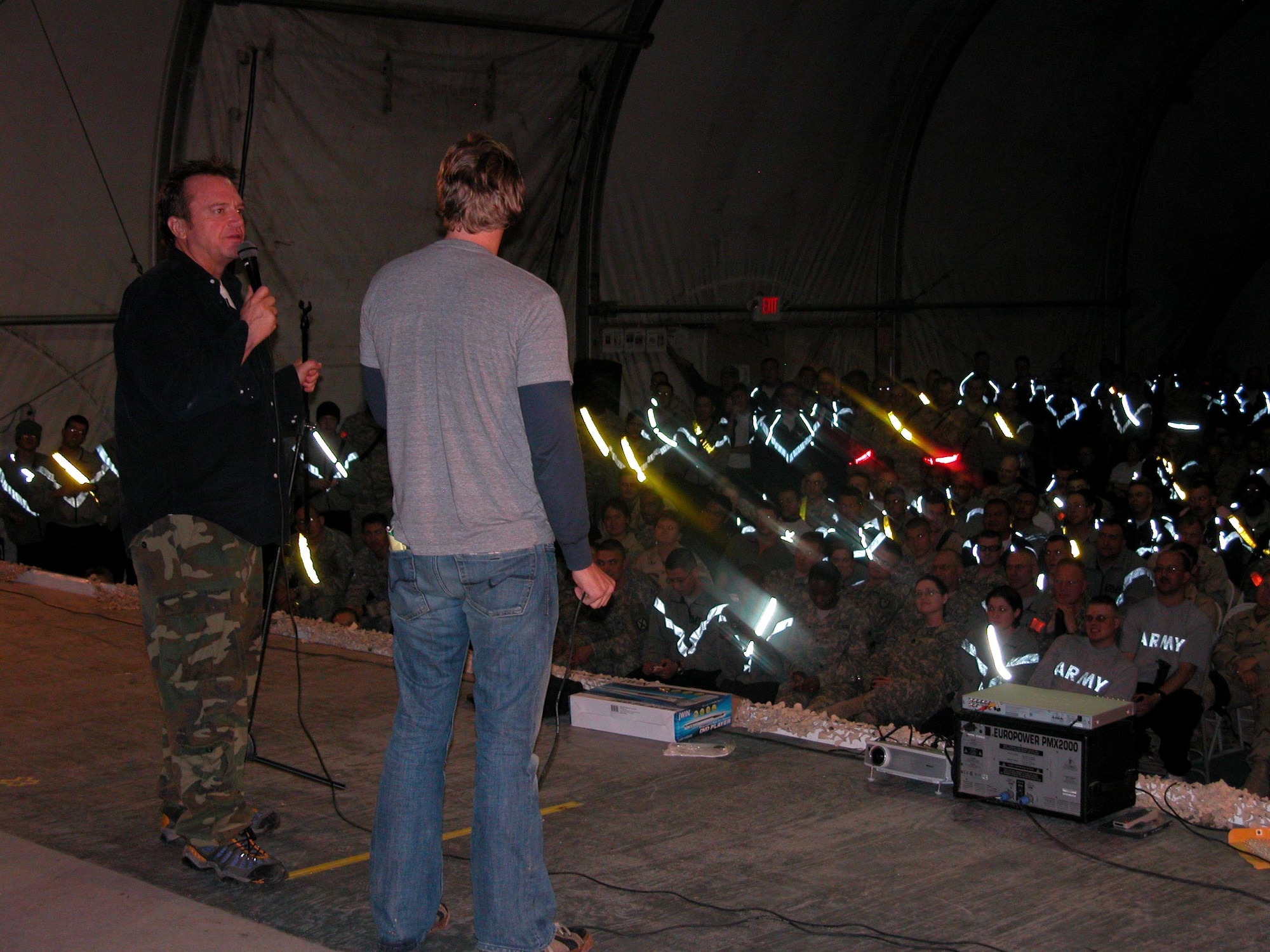 BAGRAM AIRFIELD, Afghanistan -- Comedians Tom Arnold, left, and Dax Shepard perform a stand-up comedy routine for more than 200 coalition forces members during a recent performance at Bagram Airfield. Air Force photo by Senior Airman Brian Stives