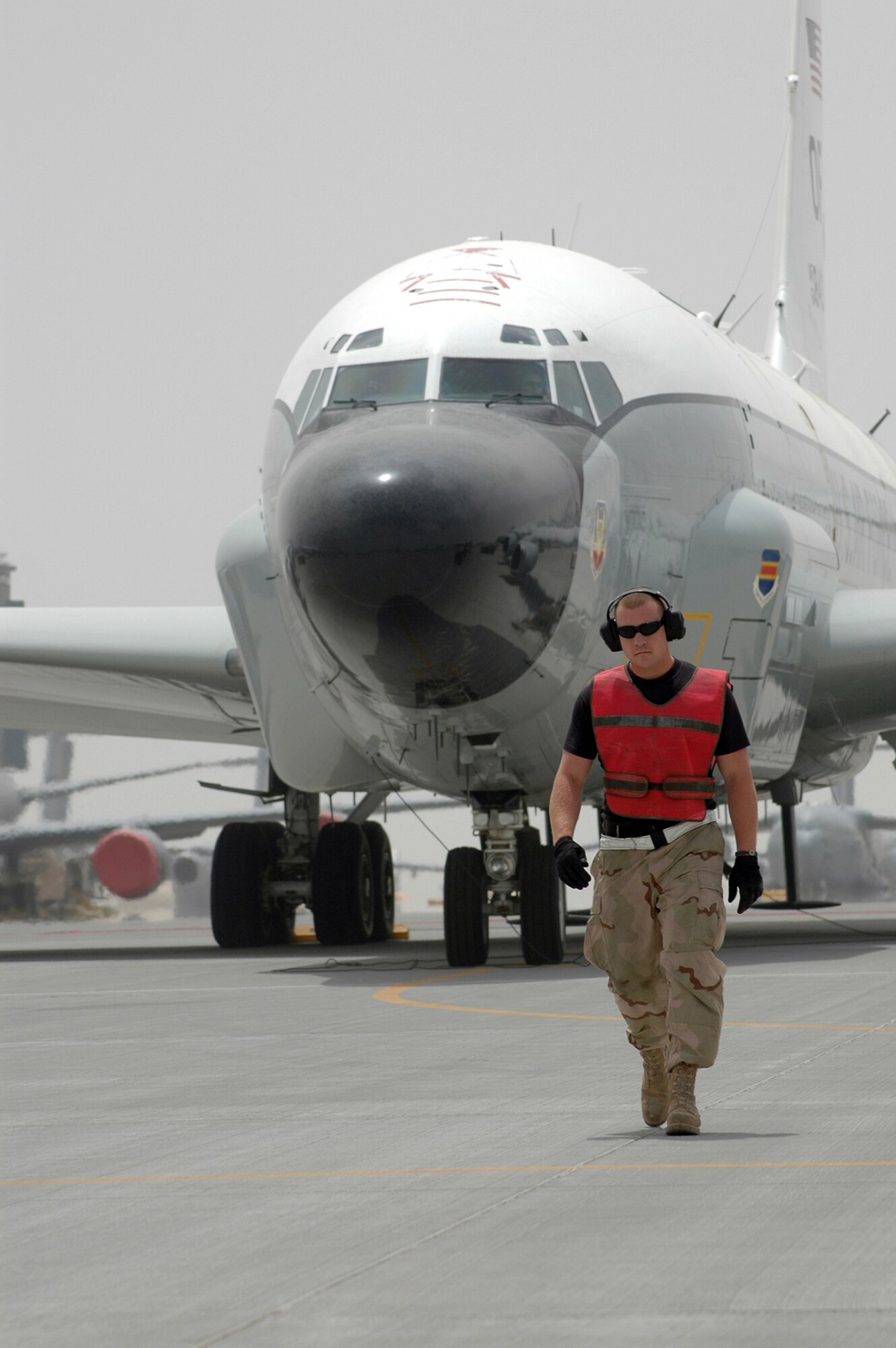 Staff Sgt. Cheyenne Bode, an electrical and environmental craftsman, walks out to marshal the RC-135 V/W Rivet Joint from its parking space April 4 for a mission in Southwest Asia. Sergeant Bode is assigned to the 379th Expeditionary Aircraft Maintenance Squadron's 55th Aircraft Maintenance Unit. (U.S. Air Force photo/Senior Airman Erik Hofmeyer) 