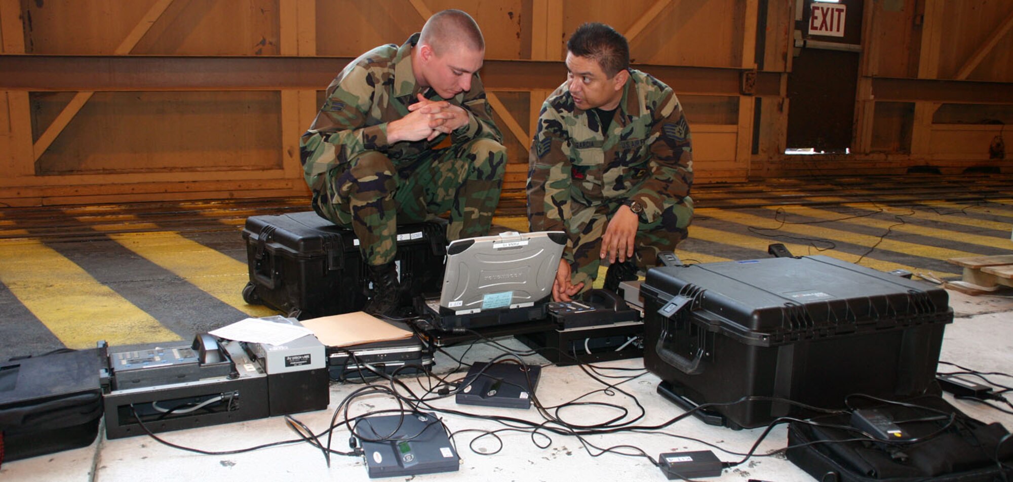 (TINKER AIR FORCE BASE, Okla.) Airman 1st Class Travis McManus and Staff Sgt. Raphael Garcia, 752nd Communications Squadron, test a secure communications fly-away kit before an E-3 deployment. (Air Force photo by Staff Sgt. Stacy Fowler)