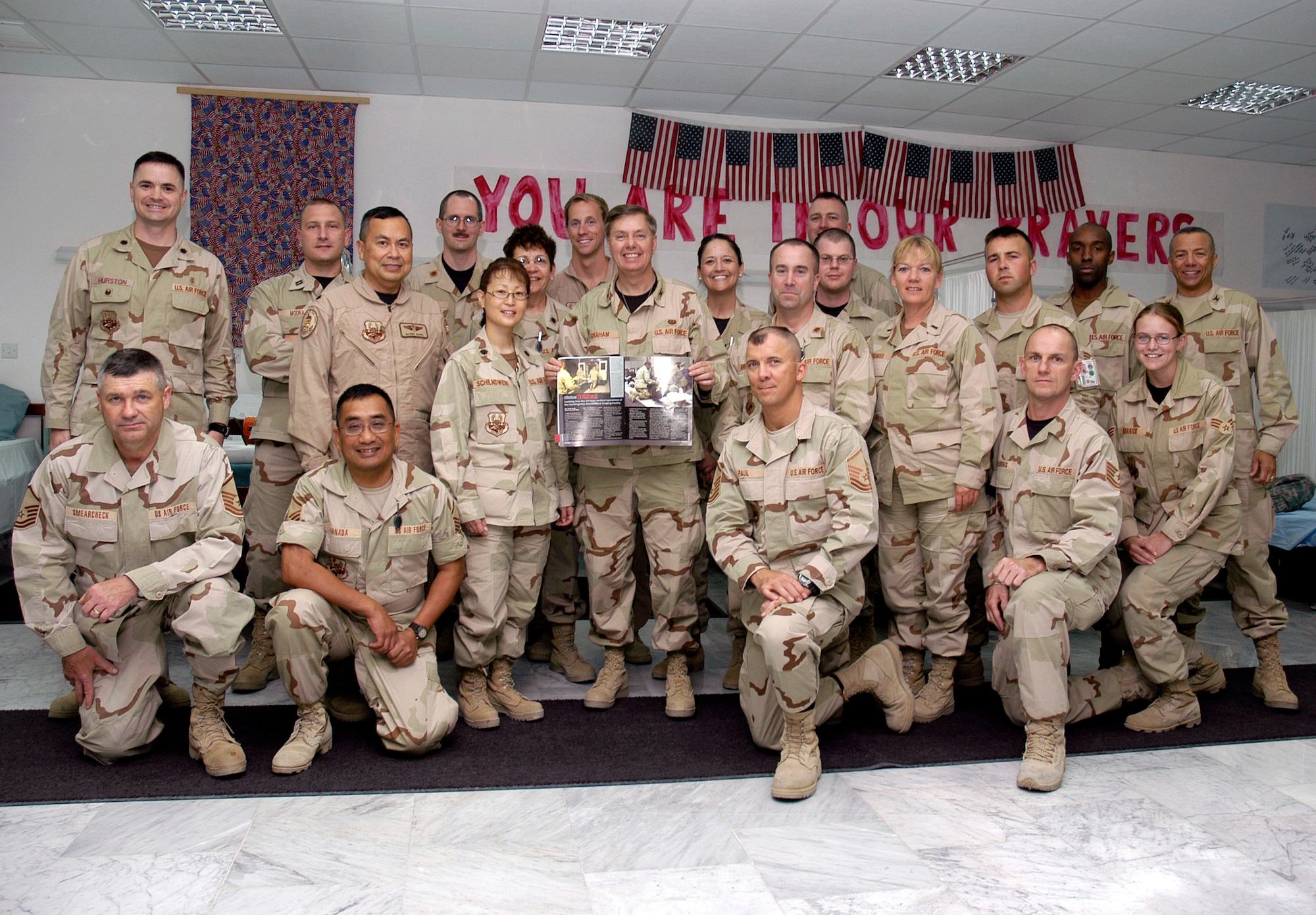 Col. Lindsey Graham poses with members of the 386th Expeditionary Medical Group April 9 in the Contingency Air Medical Staging Facility in Southwest Asia. The senior senator from South Carolina is a Reserve judge advocate. He recently spent two days in Iraq with Sen. John McCain, then another eight days as a JA with the Multinational Force, Iraq. Colonel Graham is holding a copy of the Desert Voice open to an article that was written on the CASF. (U.S. Air Force photo/Staff Sgt. Ian Carrier) 
