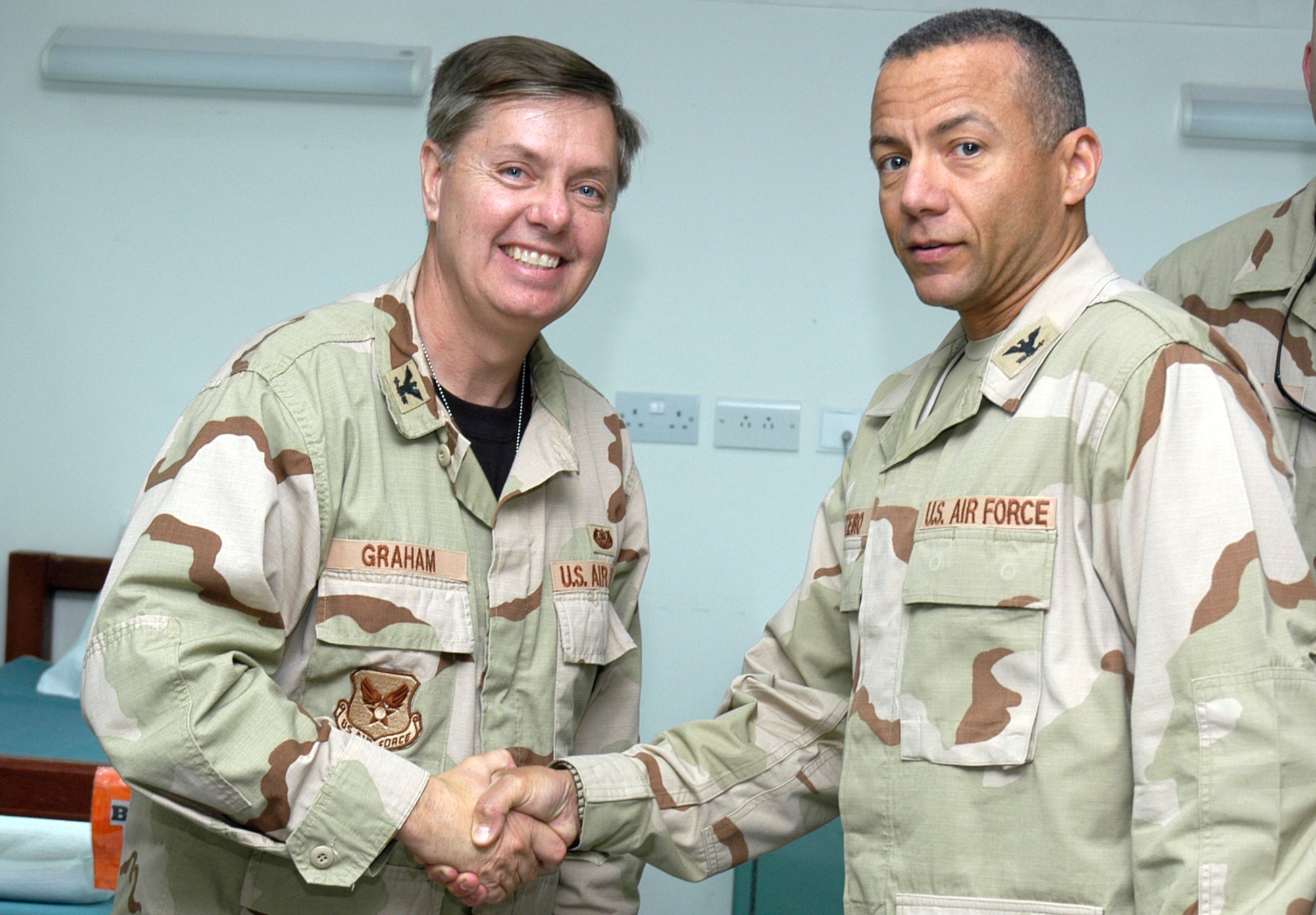 SOUTHWEST ASIA -- Col. Lindsey Graham, a Senior Senator from North Carolina, is presented a 386th Expeditionary Medical Group coin by Med. Group Commander Col. Andrew Monteiro in the Contingency Air Medical Staging Facility here on the Rock on April 9, 2007. Col. Graham, a Reserve Judge Advocate, recently spent 2 days in Iraq with Senator John McCain, then another7 days as a JA with the Multinational Force, Iraq. (AF photo/Staff Sgt. Ian Carrier)                                                                                               