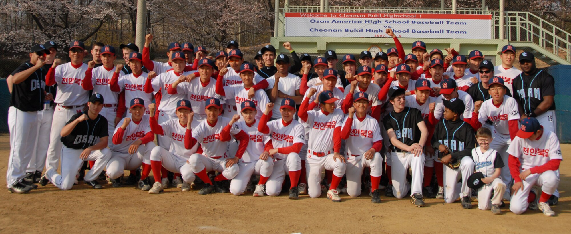 CHEONAN, Republic of Korea --  The Osan American High School Cougars and Cheonan Bukil high school baseball teams pose for a picture after their first match-up April 6. (U.S. Air Force photo by Airman 1st Class Chad Strohmeyer)