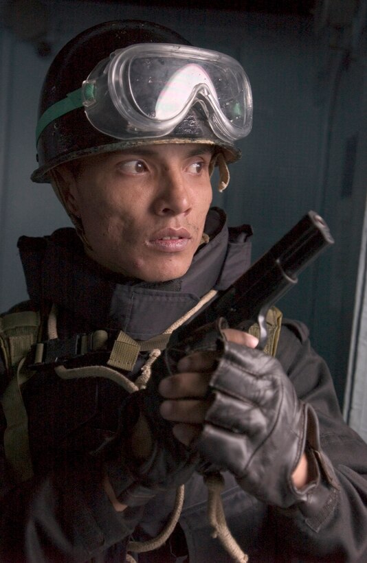 Sunjay Sbradhen, an Indian Navy member of the visit, board, search and seizure team, holds a position on the bridge of the USS Mustin during a visit, board, search and seizure drill as part of Exercise Malabar 07-01, a U.S.-Indian Navy bilateral exercise in the Philippine Sea off the coast of Okinawa, April 7, 2007.
