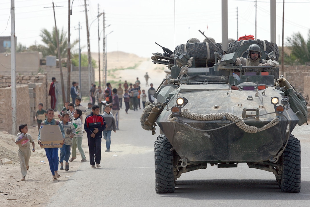 Children in the city of Reyanah chase after the light armored vehicles of the Jump Team for 1st Light Armored Reconnaissance Battalion, Regimental Combat Team 2, after the Marines stopped to visit with children of Anah, Iraq, March 27, 2007.