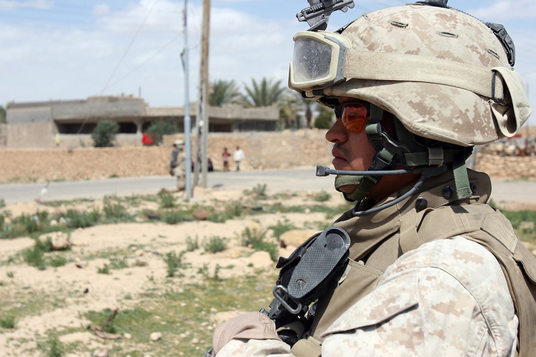 U.S. Marine Sgt. Mark A. Zimmerman, a rifleman with the Jump Team, 1st Light Armored Reconnaissance Battalion, Regimental Combat Team 2, provides security while Marines distribute goods to the citizens of Reyanah, Iraq, March 27, 2007.