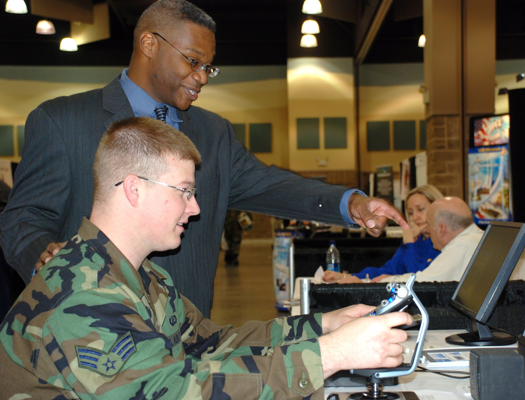 Warren Daniel, chief executive officer for Commercial Level Simulations, Ltd., assists Senior Airman Stephen Burk, an 82nd Contracting Squadron contracting specialist, with CLS's F-117A simulation software. Warren Daniel was one of 80 vendors that participated in the 10th Annual 2007 Government Purchase Card Vendor Day event April 10, sponsored by 82 CONS and the National Contract Management Association. (U.S. Air Force photo/Master Sgt. Jennifer Isom)