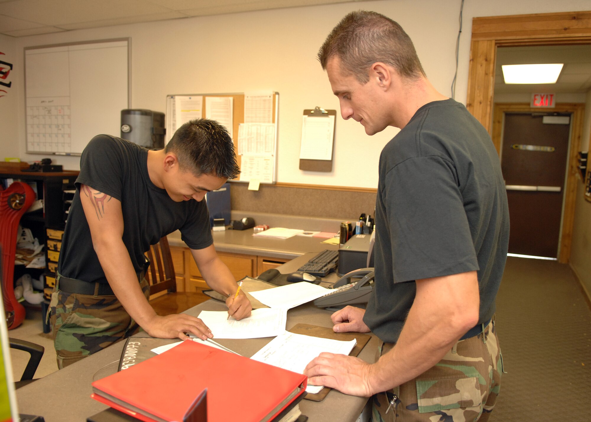 Senior Airman Francisco Macatol and Tech. Sgt. Leroy Brooks, both from the 49th Logistics Readiness Squadron, check paperwork for errors at the Vehicle Maintenance Customer Service Office. The customer service office is the first place customers see when requesting assistance and is an integral part in Vehicle Maintenance customer satisfaction and overall mission success. (U.S. Air Force photo by Airman 1st Class Jamal Sutter)