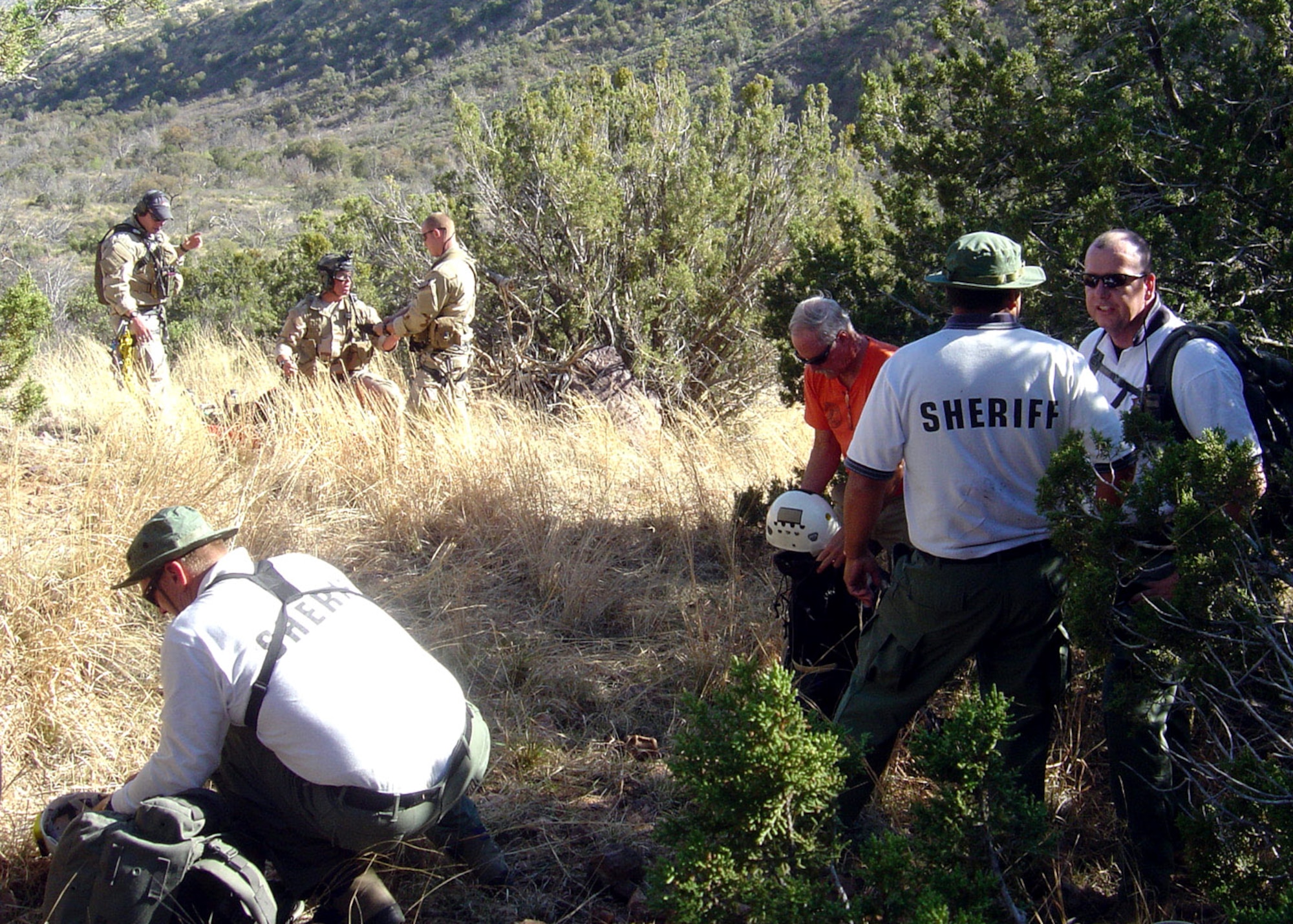 Members of the Pima County Sheriff Search and Rescue Team, Southern Arizona Rescue Association and 48th Rescue Squadron pararescuemen from Davis-Monthan Air Force Base coordinate the evacuation of a simulated injured and lost hikers during a local civil search and rescue exercise April 2 at Coronado National Forest, Ariz. (U.S. Air Force photo/Tech. Sgt. Chad Watts)