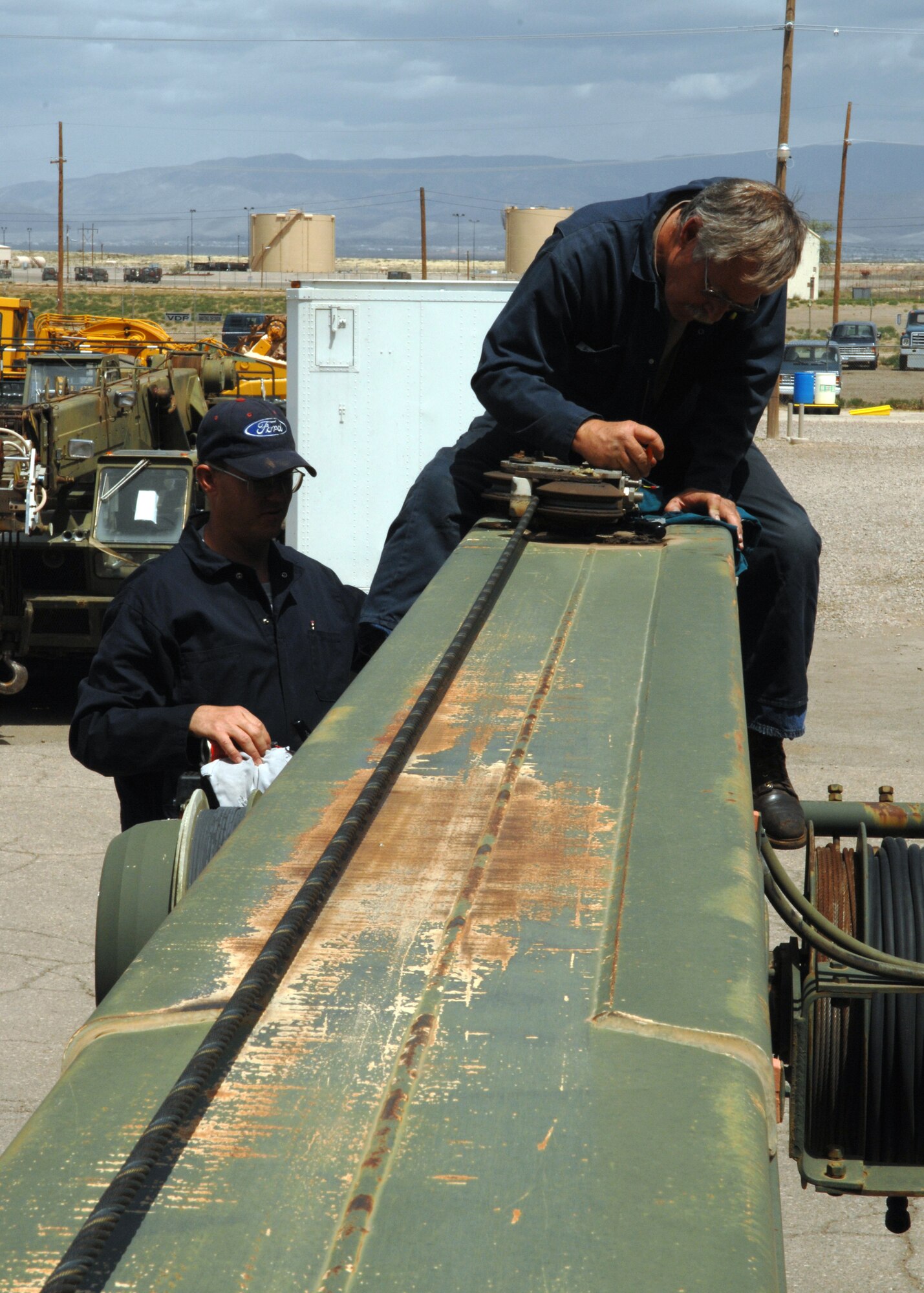 Mr. Ken Davis, 49th Logistics Readiness Squadron, assisted by Army Reserve Sergeant Major Scott White, repairs the kruger load safety system of a crane. The crane is used for many projects and jobs done by the 49th Civil Engineers Squadron. (U.S. Air Force photo by Airman 1st Class Jamal Sutter)