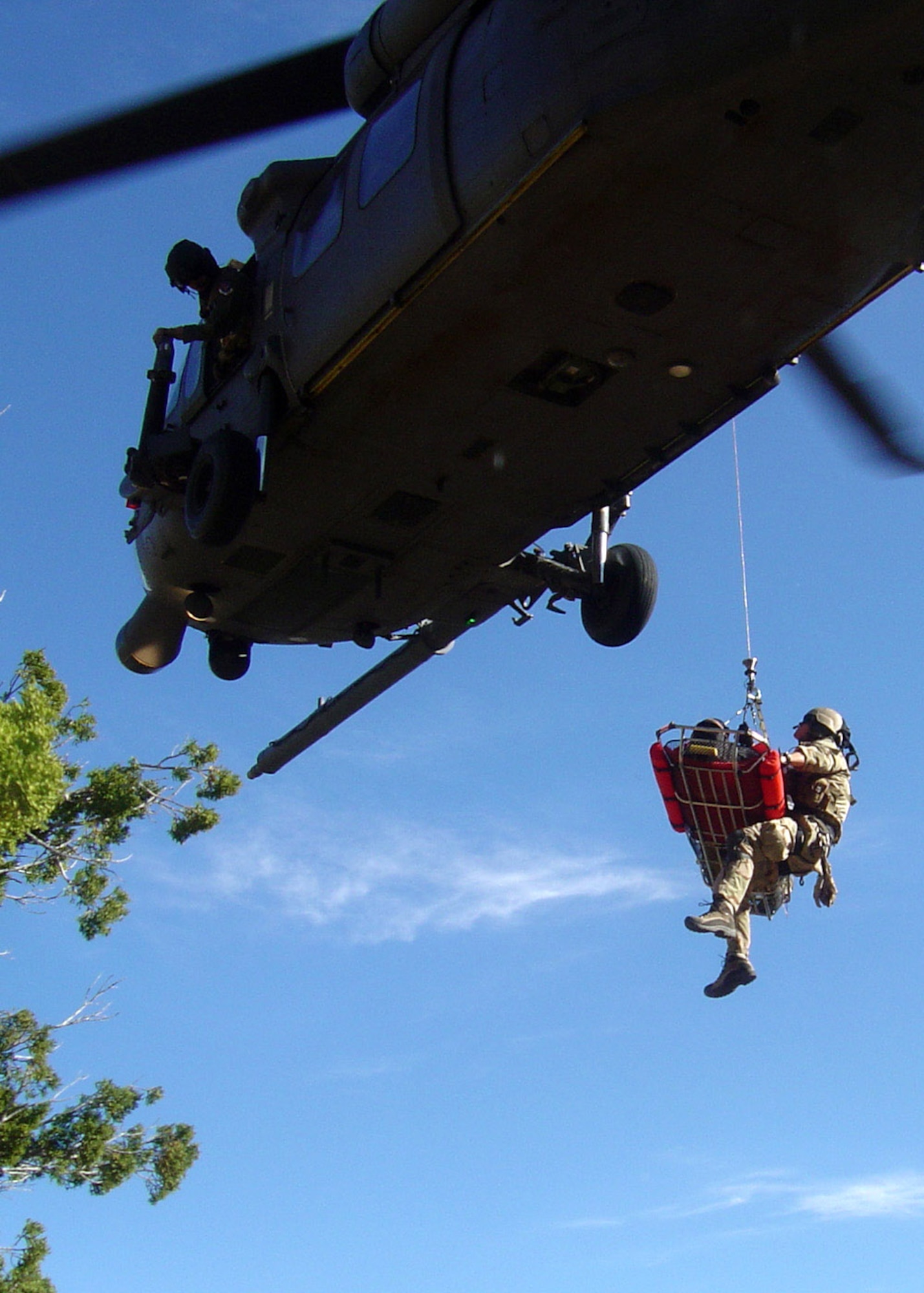 A 48th Rescue Squadron pararescuman and an injured hiker are hoisted into a hovering HH-60 Pave Hawk during an exercise to strengthen relations between Davis-Monthan Air Force Base Airmen and local civilian rescue agencies April 2 at Coronado National Forest in Arizona. The hiker was airlifted to University Medical Center in Tucson, Ariz., to complete the exercise. (U.S. Air Force photo/Tech. Sgt. Chad Watts)