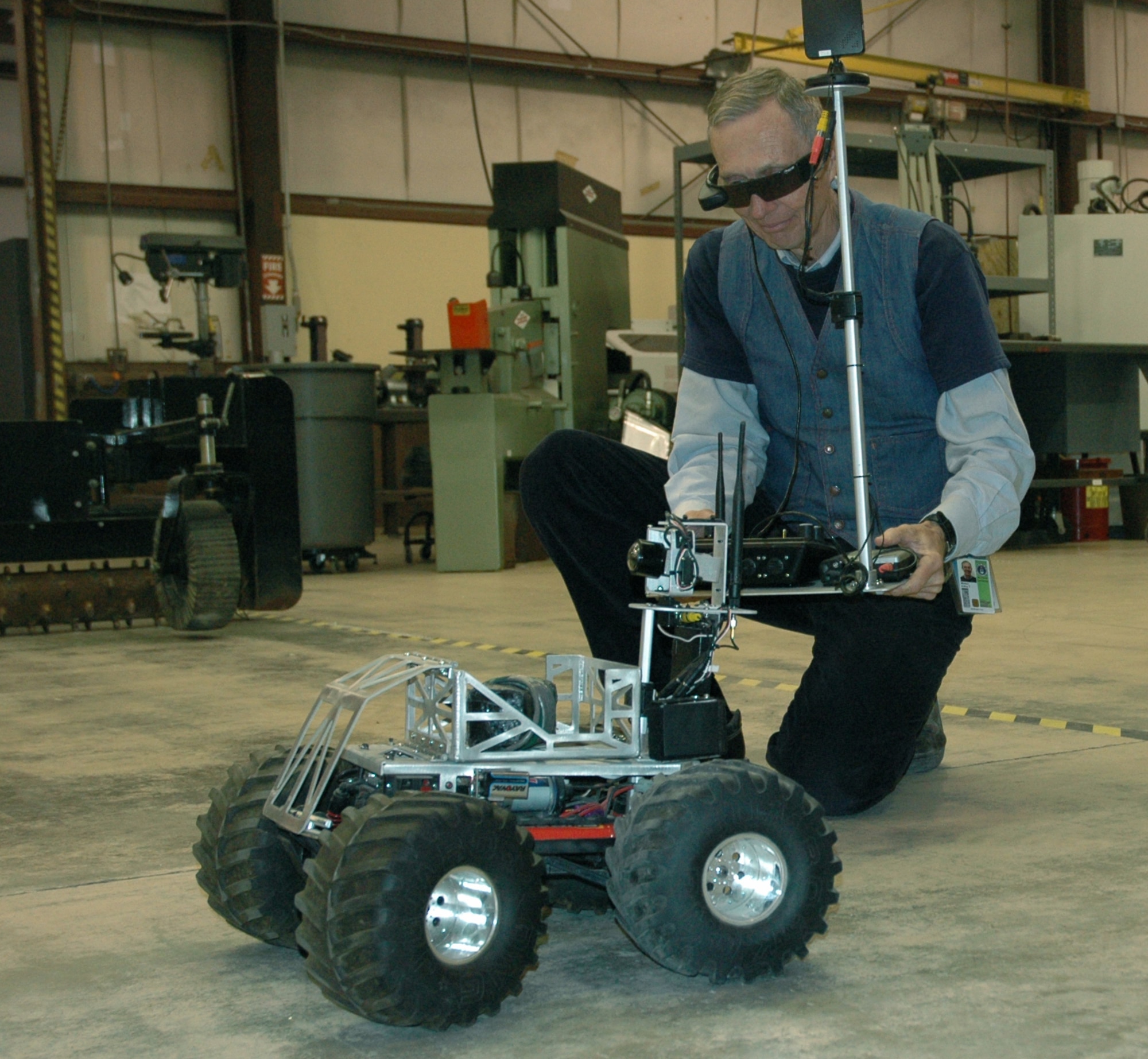 Arthur Morton, Air Force Research Laboratory robotics engineer, operates a "bomb bot."  This modified remote-control truck can roll into an area of operation and drop off a bomb from its basket using a dumping mechanism similar to a child's construction truck.  Its attached hand-held camera also provides surveillance capability. Approximately 6,000 of similar "bomb bots" have been purchased by the U.S. military for use in the field.  (U.S. Air Force Photo by Chrissy Cuttita)