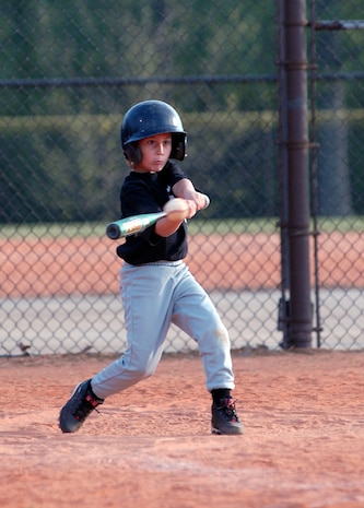 Steven Boudreaux, 7, son of retired Master Sgt. Steven and Master Sgt. Kathryn Boudreaux, hits the ball for the White Sox in their game against the Cubs April 6. (Air Force photo/Airman Melissa Harper)