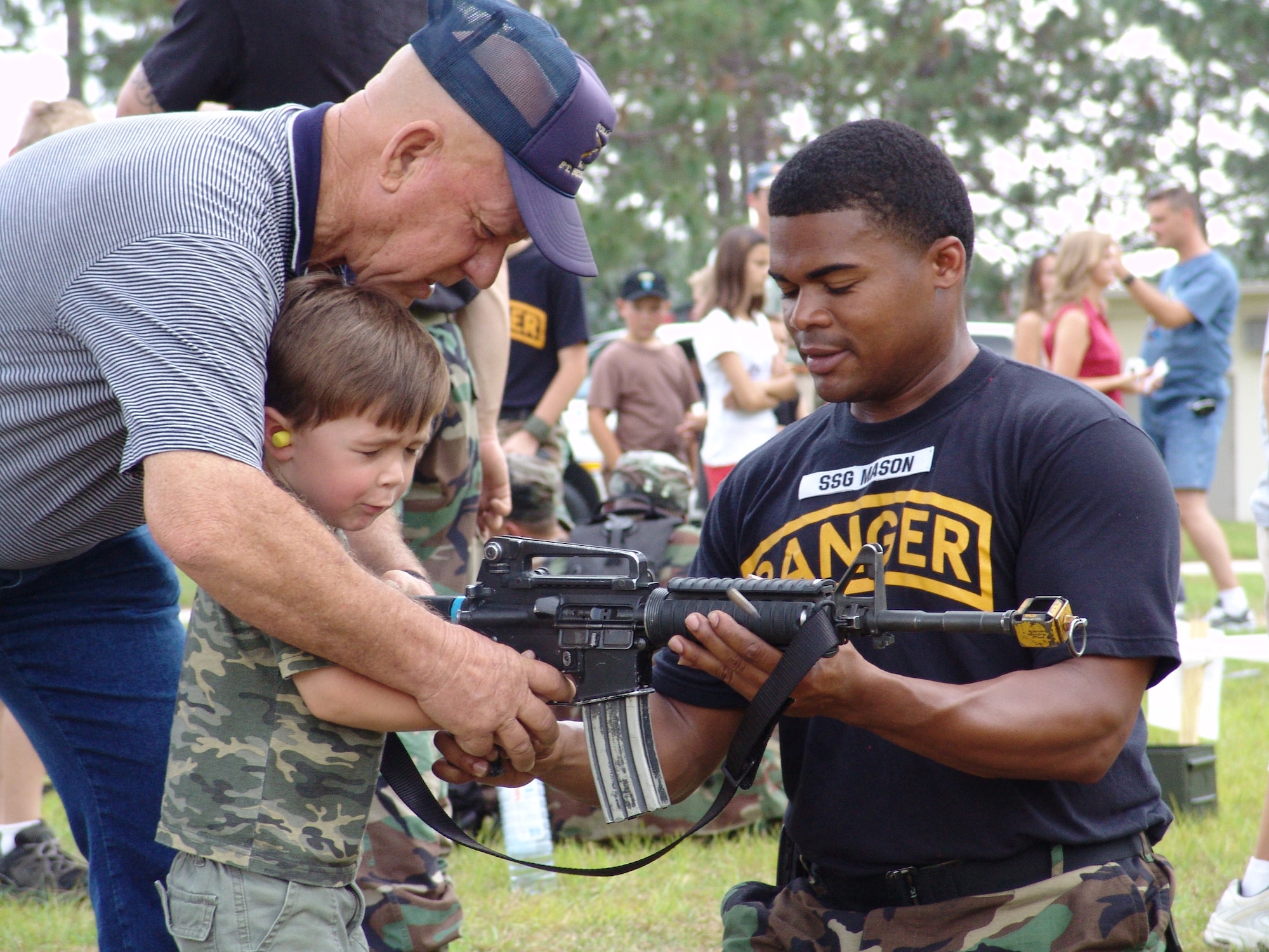 CAMP RUDDER, Fla. -- U.S. Army Ranger Staff Sgt. Timothy Mason holds the M-4 rifle for three-year old Brandon Emerick while Carlos Duncan, Brandon's great grandfather, helps him squeeze the trigger during a previous Ranger Open House. The 6th RTB, stationed at Auxiliary Field 6 on the Eglin Air Force Base military reservation, will be hosting a 5k and 10k race prior to the Ranger Camp's annual Open House event May 6. Demonstrations will include rappelling, weapons, parachute as well as boat and reptile displays. (U.S. Air Force photo by Staff Sgt. Mike Meares)                        