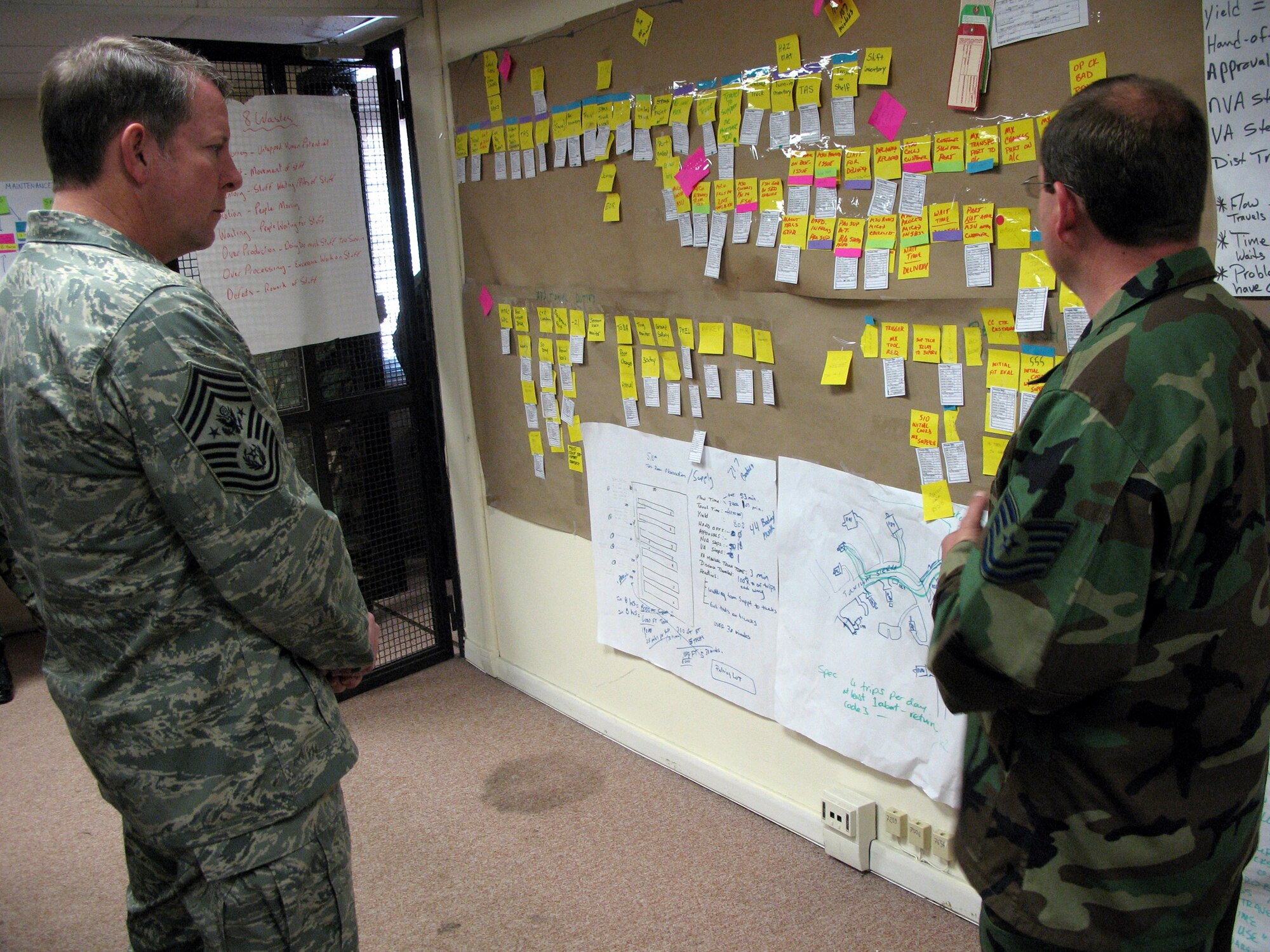 Chief Master Sergeant of the Air Force Rodney J. McKinley (left) receives an AFSO 21 briefing from Tech. Sgt. Frank William.  Airmen in the 31st Aircraft Maintenance Group at Aviano Air Base, Italy, worked for months on a plan to cut the costs of aircraft sortie generation and maintenance. The planning team originally worked to cut costs in their own operations, but their model could be implemented by air bases around the globe.  (U.S. Air Force photo/Airman 1st Class Justin Goodrich)