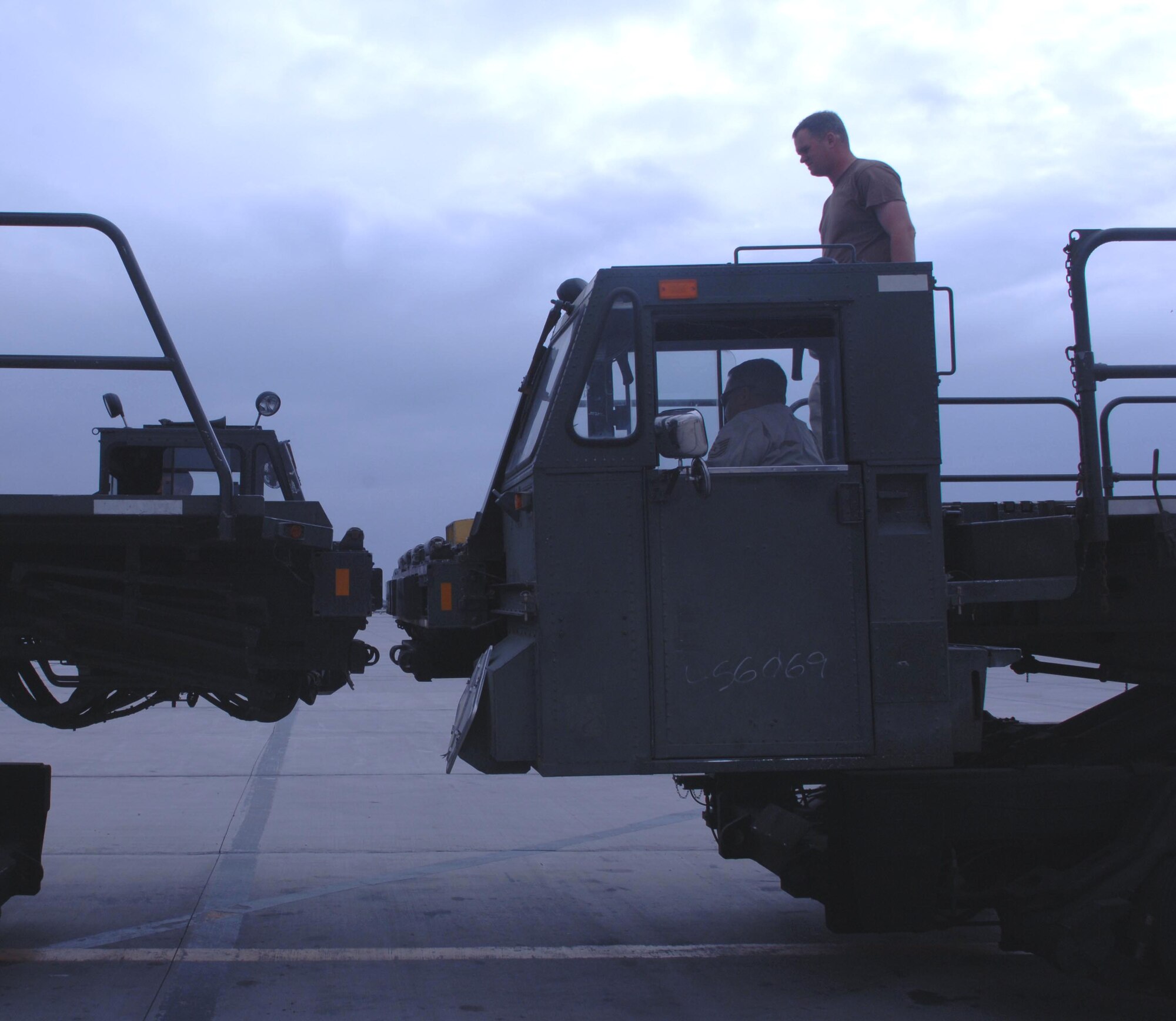 Tech Sgt. Duane Kaiser stands and provides guidence to K-loader driver Tech Sgt. Luis Quiles as they facilitate lining up two K-loaders back to back for the off loading of a cargo aircraft for Force Provider. Both Airmen are part of the 455th Expeditionary Logistics Readiness Squadron. (U.S. Air Force photo/ Staff Sgt. Kevin Tomko)