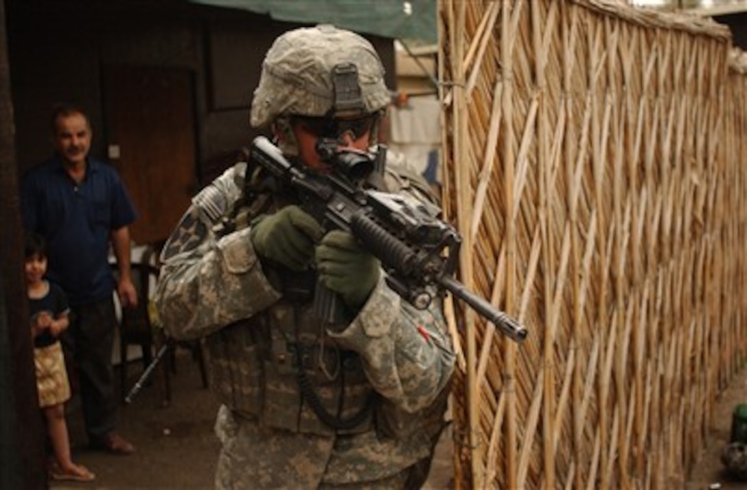 U.S. Army Sgt. 1st Class Steven Loduha provides security in front of a house in Mansour, Iraq, on April 8, 2007, during a combined cordon and search mission with Iraqi army soldiers.  Loduha is assigned to Black Hawk Company, 1st Battalion, 23rd Infantry Regiment.  