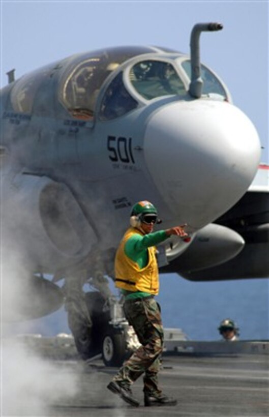 An air department flight deck supervisor signals to the waist catapults safety observer as an EA-6B Prowler aircraft stages to launch from catapult number four aboard USS Harry S. Truman (CVN 75) on April 1, 2007.  The Truman is underway in the Atlantic Ocean conducting training.  
