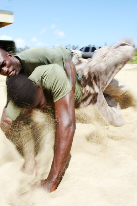 Staff Sgt. Kenneth Davis, martial arts instructor, slams Cpl. Karim Baker, maintenance company, into the sand during the martial arts skills portion of the Combat Service Support Group-3 Warrior Challenge Biathlon, April 11.
