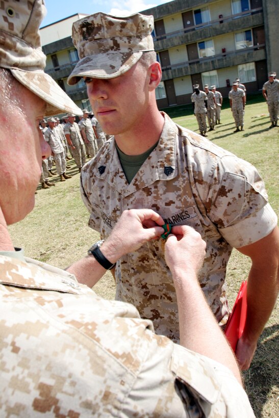 Colonel Donald Matthew, Commanding Officer, Combat Service Support Group-3 pins a Navy Achievement Medal onto Sgt. Matthew Kozel, for winning the CSSG-3 Warrior Challenge Biathlon with a total time of 4:32:00, April 11.