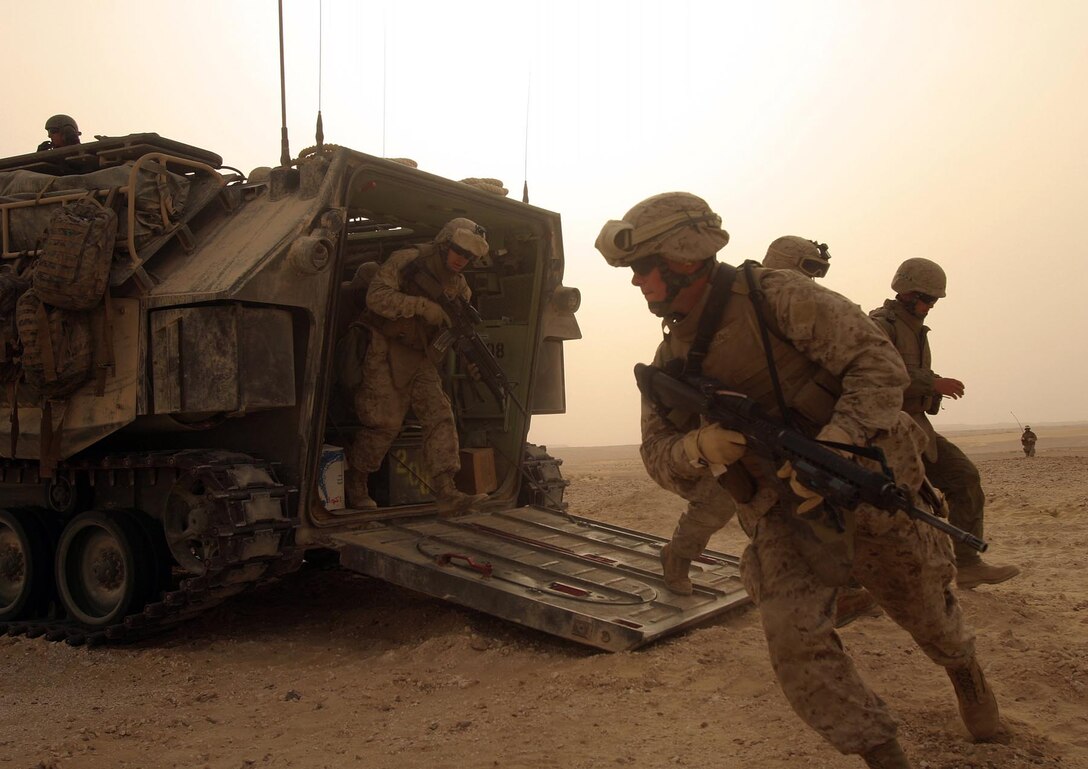 Dismounting an Assault Amphibian Vehicle, Marines and Sailord from Company F, Battalion Landing Team 2/2, 26th Marine Expeditionary Unit, begin a live-fire mechanized assault at Ghalil Range, Qatar, April 12, 2007.   The training was part of the bilateral exercise Eastern Maverick '07, held between the MEU and regional forces April 7-15. (Official USMC photo by Cpl. Jeremy Ross) (Released)