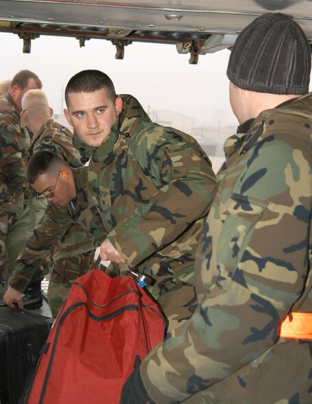 KUNSAN AIR BASE, Republic of Korea  April 13, 2007 -- Senior Airman Matthew Tremblay (center), 9th Expeditionary Fighter Squadron, passes luggage to a fellow Airman here. Airman Tremblay and more than 200 Airmen redeployed to their home installation Holloman Air Force Base, N.M. after culminating a four month air expeditonary force assignment. (U.S. Air Force photo/Senior Airman Stephen Collier) 