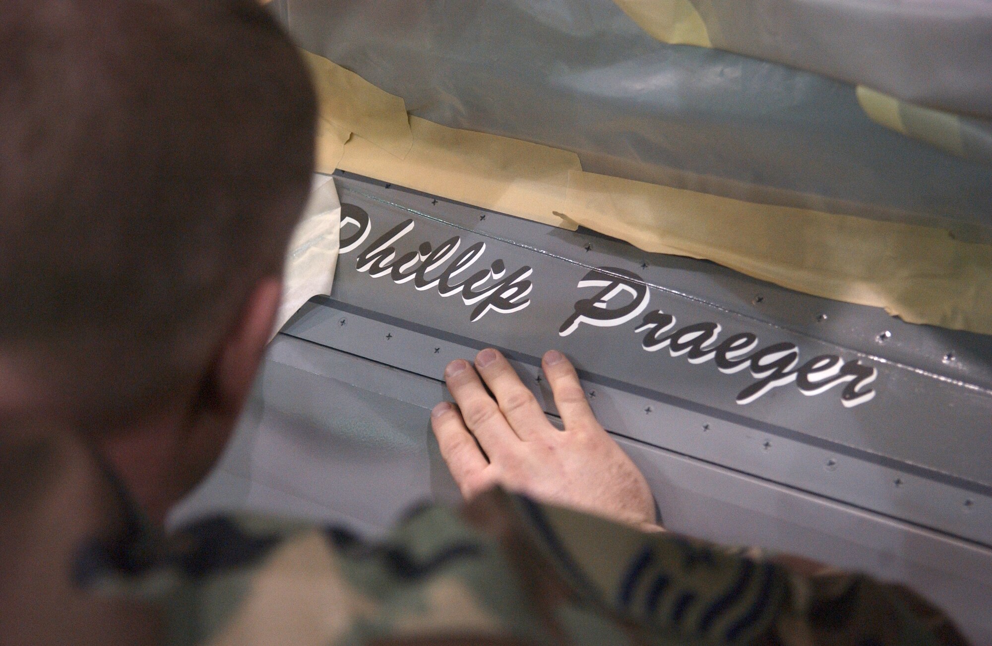 EIELSON AIR FORCE BASE, Alaska -- Master Sgt. Sammy Pettit, 354th Maintenance Squadron, Aircraft Structural Maintenance, places vinyl names of the Crew Chiefs that maintain 'ICEMAN One', the 354th Wing Commanders', F-16 Fighting Falcon on April 12. The new tail design and paint touch up will help prevent future corrosion. (U.S. Air Force Photo by Airman 1st Class Jonathan Snyder) 