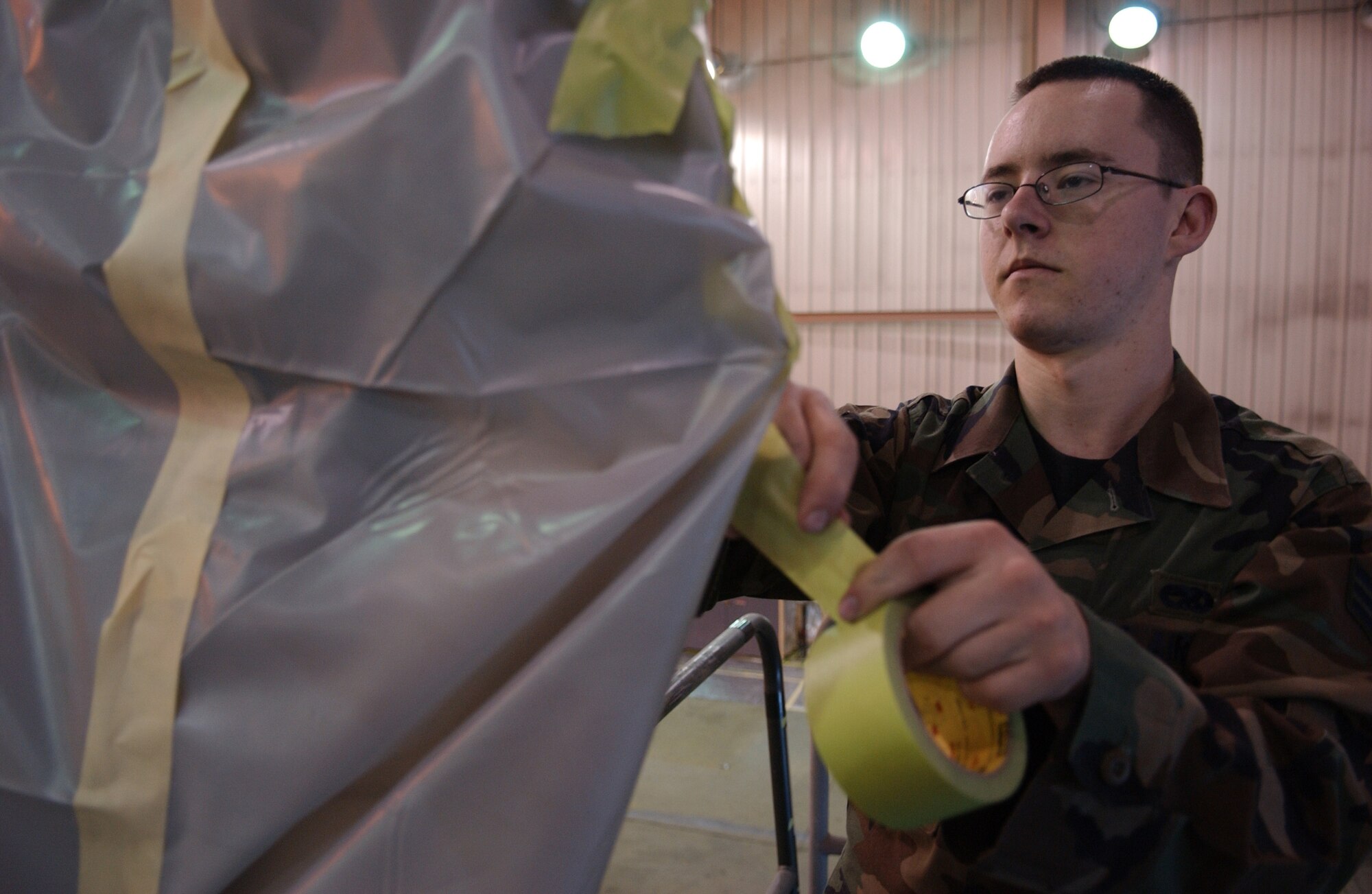 EIELSON AIR FORCE BASE, Alaska -- Senior Airman Richard Holguin, 354th Maintenance Squadron, Aircraft Structural Maintenance, masks 'ICEMAN One', the 354th Wing Commanders', F-16 Fighting Falcon on April 11. The new tail design and paint touch up will help prevent future corrosion. (U.S. Air Force Photo by Airman 1st Class Jonathan Snyder)