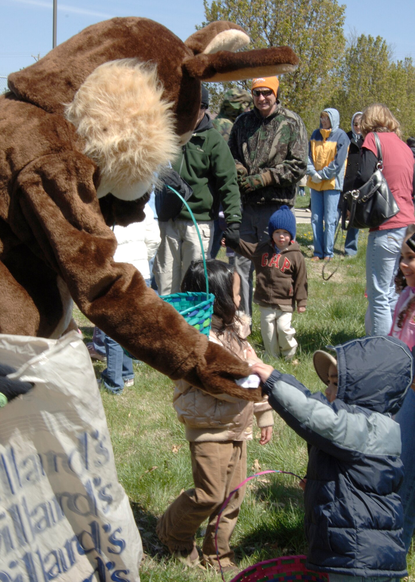 Amanda Pozehl, dressed at as the Easter Bunny, hands out eggs to Team Mcconnell family members during the an Easter egg hunt April 7 at the base housing softball field. (Air Force photo by Airman Justin Shelton 22nd Communications Squadron)
