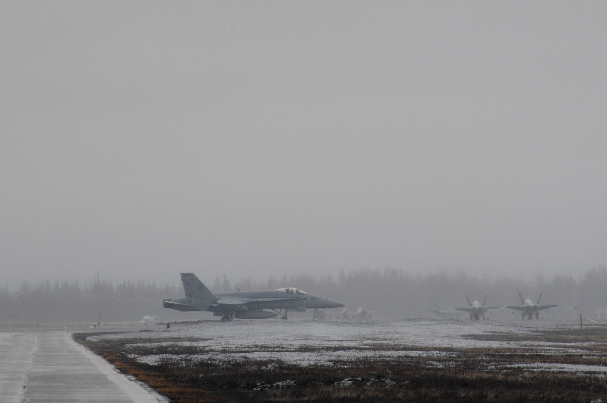 EIELSON AIR FORCE BASE, Alaska -- Navy F/A-18 aircraft from Strike Fighter Squadron Eight Seven (VFA-87) taxi for take off through the snow and fog during Red Flag-Alaska 07-1 here on April 12. Red Flag-Alaska is a Pacific Air Forces-directed field training exercise for U.S. forces flown under simulated air combat conditions. It is conducted on the Pacific Alaskan Range Complex with air operations flown out of Eielson and Elmendorf Air Force Bases. 
(U.S. Air Force Photo by Staff Sgt Joshua Strang) 