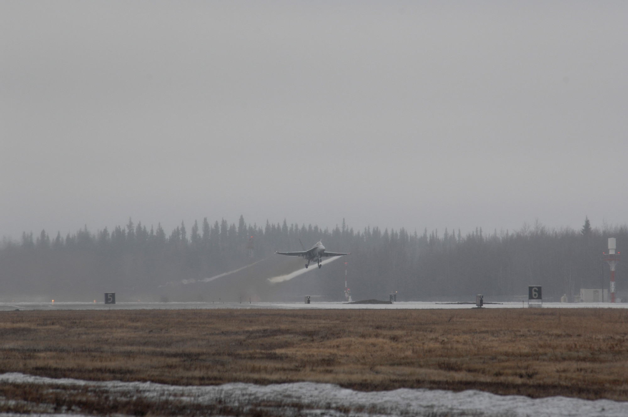 EIELSON AIR FORCE BASE, Alaska -- A Navy F/A-18  from Strike Fighter Squadron Eight Seven (VFA-87) takes off through the snow and fog during Red Flag-Alaska 07-1 here on April 12. Red Flag-Alaska is a Pacific Air Forces-directed field training exercise for U.S. forces flown under simulated air combat conditions. It is conducted on the Pacific Alaskan Range Complex with air operations flown out of Eielson and Elmendorf Air Force Bases. 
(U.S. Air Force Photo by Staff Sgt Joshua Strang) 