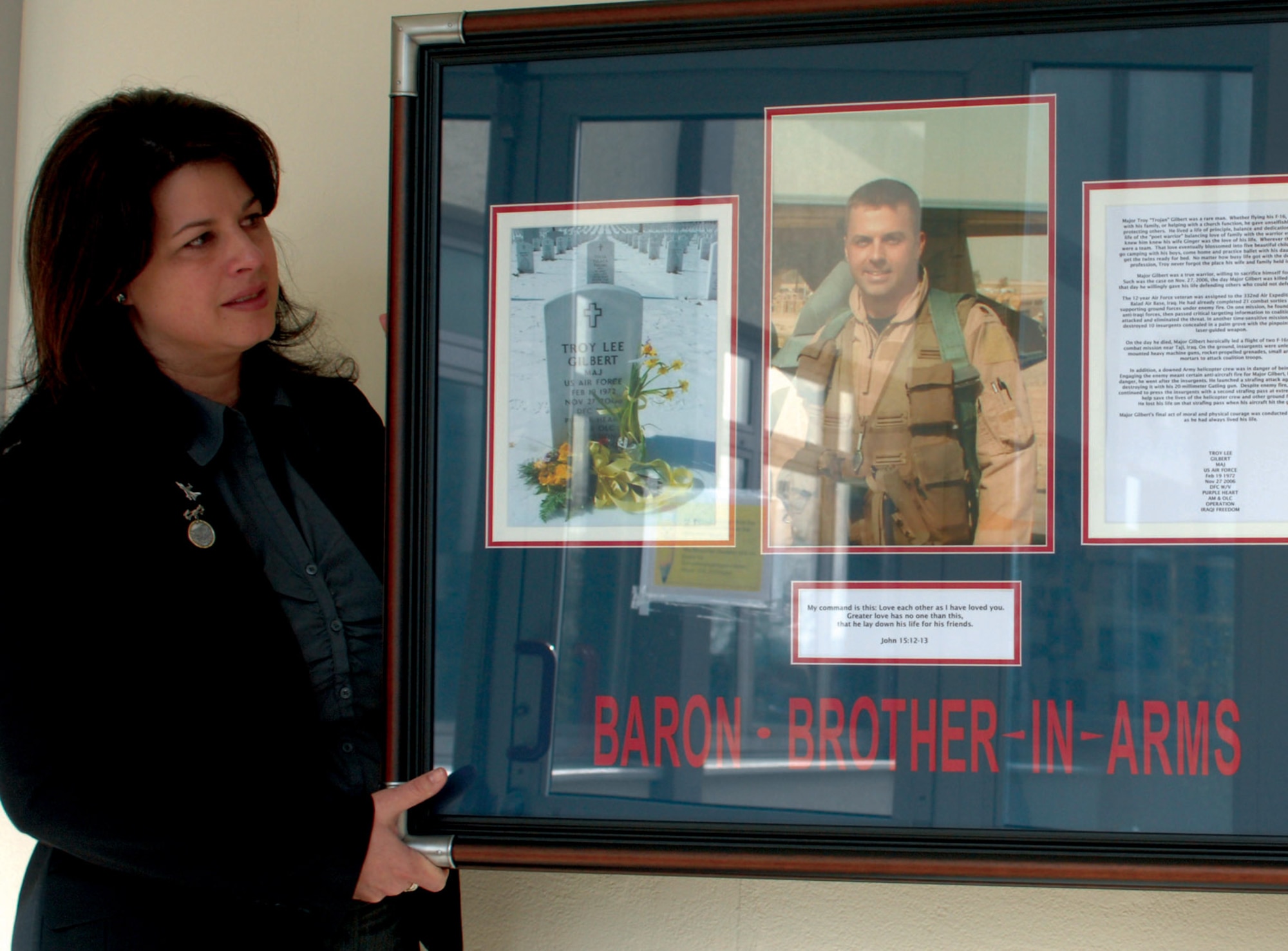 Lenora Woodcock helps hang a commemorative plaque hung in the memory of Maj. Troy Gilbert April 5 at Bitburg High School near Spangdhalem Air Base, Germany. Major Gilbert was supporting Operation Iraqi Freedom when he lost his life when his F-16 Fighting Falcon crashed 20 miles northwest of Baghdad. Mrs. Woodcock was the event coordinator and the spouse of Col. William Woodcock, the former 23rd Fighter Squadron commander. (U.S. Air Force photo/Airman 1st Class Emily Moore) 
