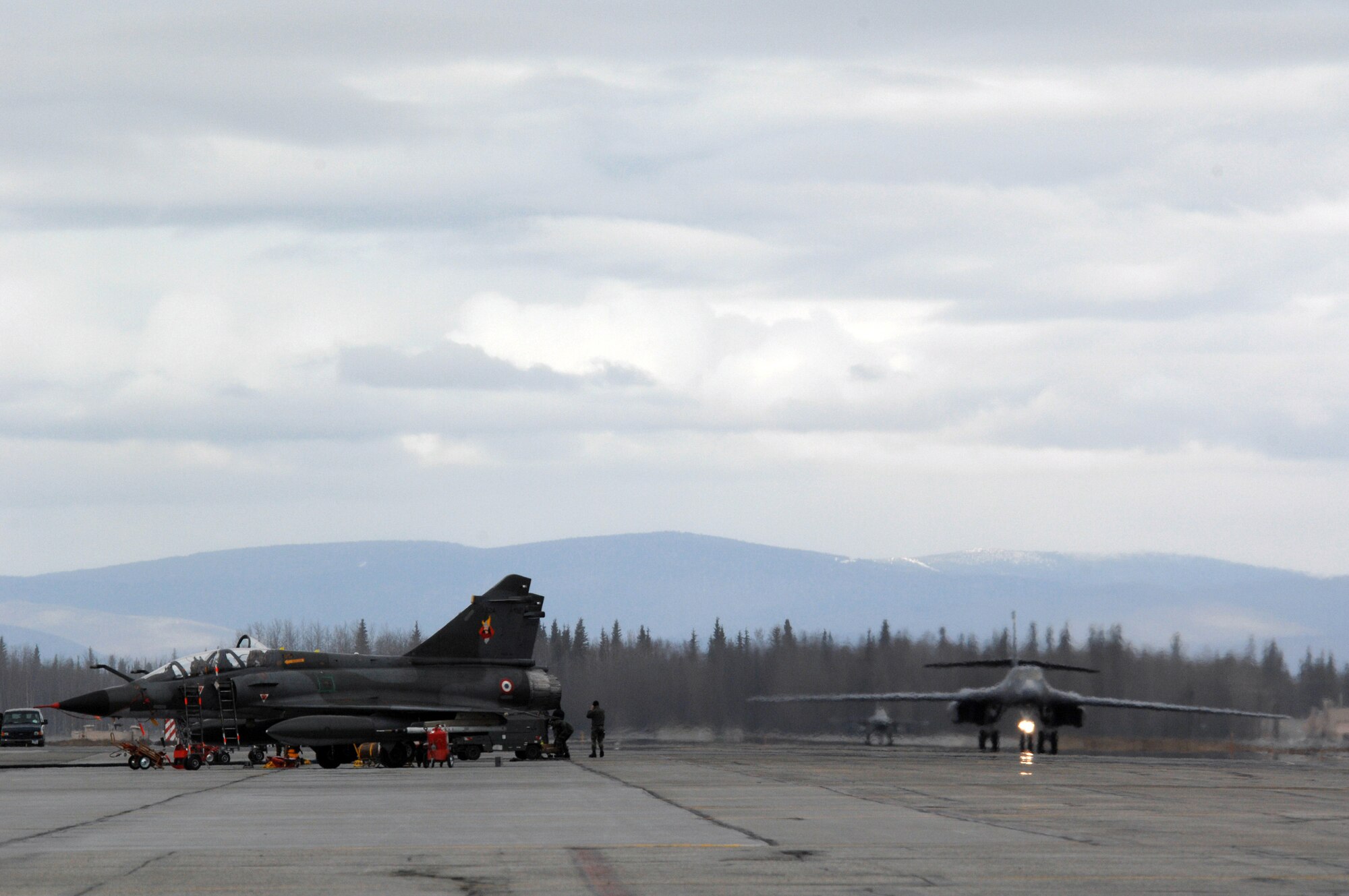 EIELSON AIR FORCE BASE, Alaska -- A B-1B Lancer, 28th Bomb Wing, Ellsworth Air Force Base, South Dakota and an F-16 Fighting Falcon, 18th Fighter Squadron, Eielson Air Force Base, Alaska taxi past French Dassault M2000 Mirage aircraft from the Armee de l'Air during Red Flag-Alaska 07-1 here on April 11. Red Flag-Alaska is a Pacific Air Forces-directed field training exercise for U.S. forces flown under simulated air combat conditions. It is conducted on the Pacific Alaskan Range Complex with air operations flown out of Eielson and Elmendorf Air Force Bases. 
(U.S. Air Force Photo by Staff Sgt Joshua Strang) 