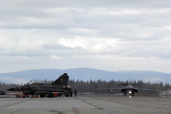 EIELSON AIR FORCE BASE, Alaska -- A B-1B Lancer, 28th Bomb Wing, Ellsworth Air Force Base, South Dakota and an F-16 Fighting Falcon, 18th Fighter Squadron, Eielson Air Force Base, Alaska taxi past French Dassault M2000 Mirage aircraft from the Armee de l'Air during Red Flag-Alaska 07-1 here on April 11. Red Flag-Alaska is a Pacific Air Forces-directed field training exercise for U.S. forces flown under simulated air combat conditions. It is conducted on the Pacific Alaskan Range Complex with air operations flown out of Eielson and Elmendorf Air Force Bases. 
(U.S. Air Force Photo by Staff Sgt Joshua Strang) 