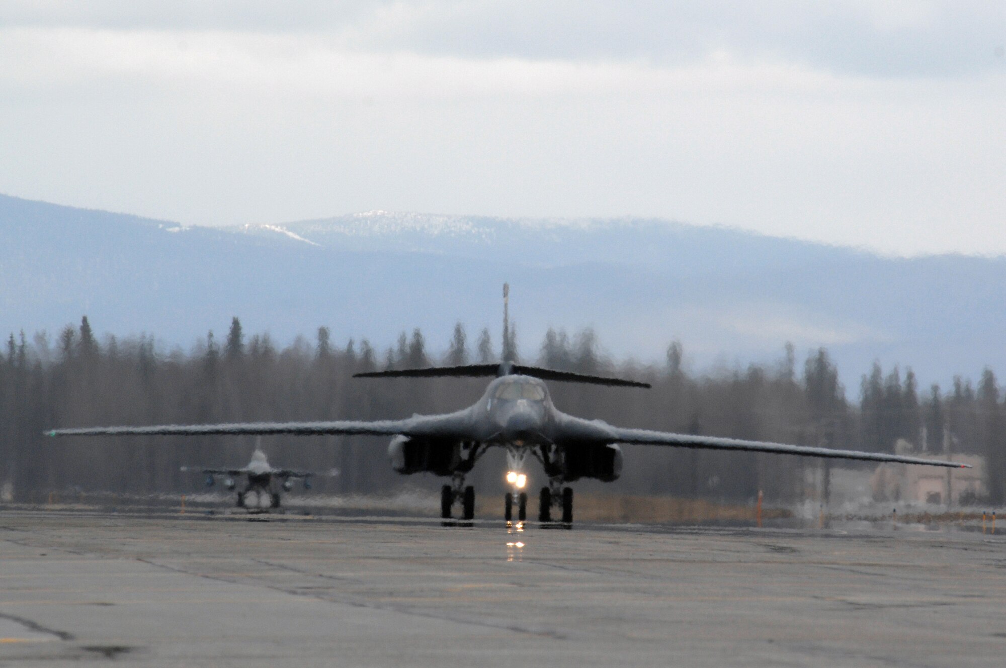 EIELSON AIR FORCE BASE, Alaska -- A B-1B Lancer, 28th Bomb Wing, Ellsworth Air Force Base, South Dakota and an F-16 Fighting Falcon, 18th Fighter Squadron, Eielson Air Force Base, Alaska taxi on the flightline during Red Flag-Alaska 07-1 here on April 11. Red Flag-Alaska is a Pacific Air Forces-directed field training exercise for U.S. forces flown under simulated air combat conditions. It is conducted on the Pacific Alaskan Range Complex with air operations flown out of Eielson and Elmendorf Air Force Bases. 
(U.S. Air Force Photo by Staff Sgt Joshua Strang) 