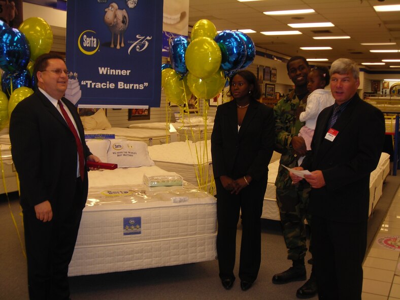 Ms. Tracie Burns, Staff Sgt. Phillip Burns, 49th Civil Engineer Squadron and their daughter, Zarea Burns accept her sweepstakes prize -- a 6.59 carat diamond bracelet from Mr. Edward Murphy, Army and Air Force Exchange Service business manager, and Mr. Lou Leyva, national acount sales manager for Serta. Ms. Burns was the first prize winner of 18 prizes given out nation wide in celebration of Serta's 75th Anniversary. The company gave away 75 carats of diamonds with a total value of $350,000. (U.S. Air Force photo by Senior Airman Terri Barriere)