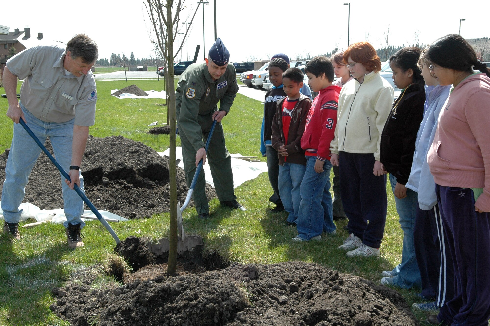 FAIRCHILD AIR FORCE BASE, Wash. -- Len Broderson, a stewardship forester at the Washington State Department of Natural Resources, and Col. Roger Watkins, 92nd Air Refueling Wing vice commander, fill in the holes where an ash tree was planted April 11 as children from the fifth grade classes of Michael Anderson Elementary School watch. The fifth graders got the chance to add in some dirt themselves for the Arbor Day event outside the “Bud Day” Survival School Building. (U.S. Air Force Photo/Airman 1st Class Kali L. Gradishar)

