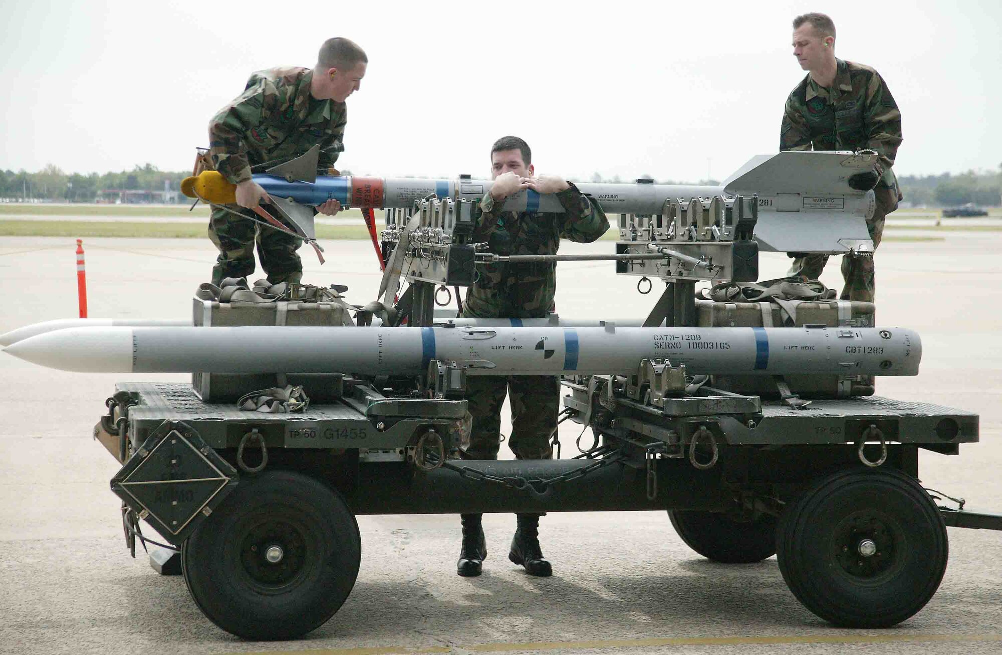 SHAW AIR FORCE BASE, S.C. -- Staff Sgt. Matthew Granger (center), Senior Airman Brian Rosnick (left) and Airman 1st Class Scott Williams, 77th Aircraft Maintenance Unit weapons loaders, reposition an AIM-9 missile to the outboard position of  the rack during the load crew of the quarter competition April 6 in Hangar 1611. Load crew competitions are designed to promote morale and increase proficiency, knowledge, professionalism and integrity. (U.S. Air Force photo/Senior Airman John Gordinier)