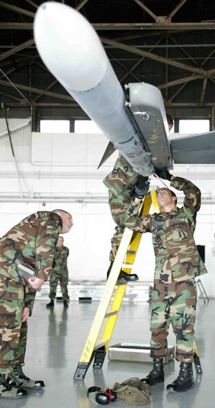 SHAW AIR FORCE BASE, S.C. -- Senior Airman Billy Mays, 79th Aircraft Maintenance Unit weapons loader, installs guidance fins on an AIM-120 missile while Staff Sgt. William Ewen, 20th Maintenance Group, evaluates Airman Mays' performance during the quarterly load crew competition April 6 in Hangar 1611. Load crew competitions are designed to promote morale, increase proficiency, knowledge, professionalism and integrity. (U.S. Air Force photo/Senior Airman John Gordinier)