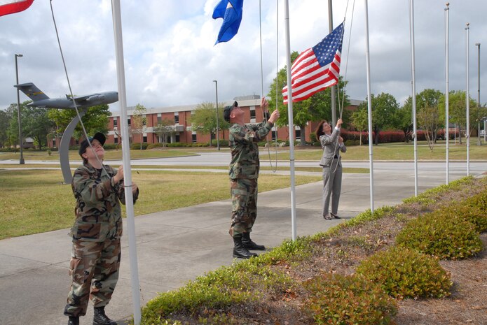 Members of the 437th Airlift Wing Protocol Office put up flags outside the wing headquarters building for a recent distinguished visitor visit. The Protocol Office won the AMC George Washington Protocol Office of the Year award for the third consecutive year in 2006. (U.S. Air Force photo/Senior Airman Sam Hymas)