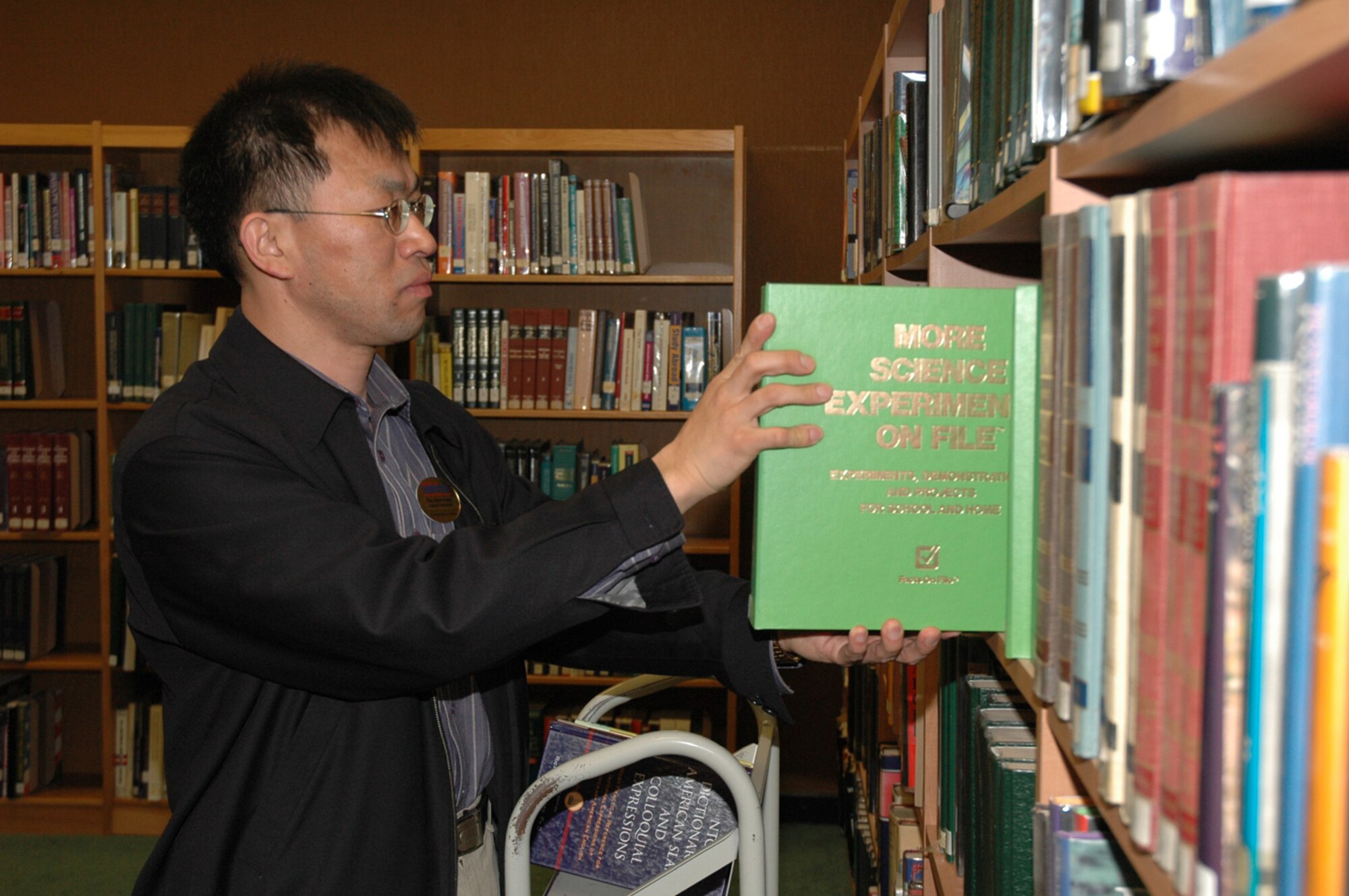 OSAN AIR BASE, Republic of Korea --  Mr. Pae, Hyon chong, reshelves books at the Osan Base Library before they open Thursday. The library has six employees and three volunteers that do everything from putting the books in order to ciculating old books. (U.S. Air Force photo by Staff Sgt. Benjamin Rojek)