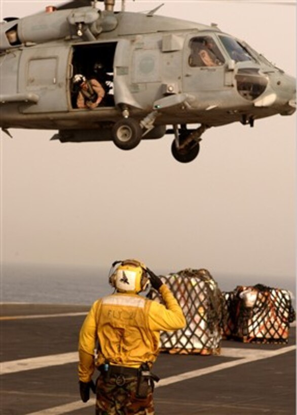 A U.S. Navy plane director aboard the USS Dwight D. Eisenhower (CVN 69) salutes an SH-60F Seahawk helicopter after it delivers supplies during an underway replenishment operation on April 11, 2007.  The Eisenhower and embarked Carrier Air Wing 7 are on a regularly scheduled deployment in the Arabian Gulf in support of maritime security operations.  