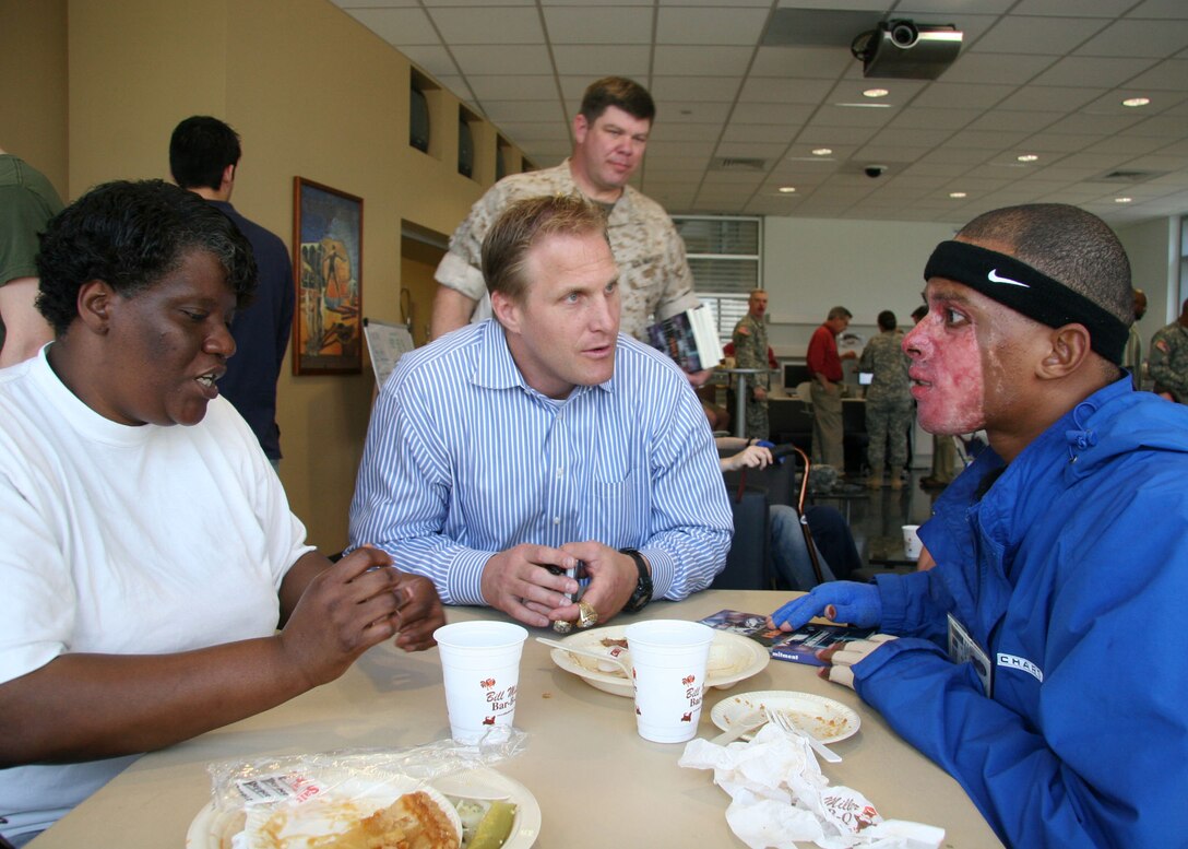Former Dallas Cowboys defensive tackle Chad Hennings talks with Marine Sgt. Shermander Jackson of Brundidge, Ala., while his mother tries on one of Hennings' Super Bowl rings during a barbecue lunch for the injured service members at the Center for the Intrepid at Brooke Army Medical Center in San Antonio April 12.