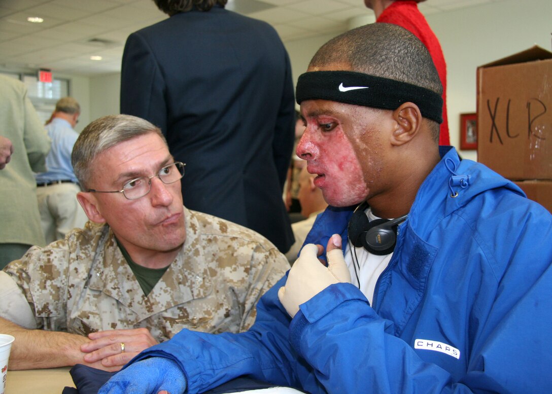 Marine Aircraft Group 41 Commanding Officer Col. Juergen 'Baron' Lukas speaks to Marine Sgt. Shermander Jackson of Brundidge, Ala., during a barbecue lunch for the injured service members at the Center for the Intrepid at Brooke Army Medical Center in San Antonio April 12.