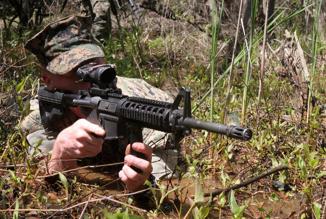 Pfc. Dustin L. Lawless, a machine gunner with Scout Reconnaissance and Surveillance Platoon, 2nd Tank Battalion, 2nd Marine Division, searches the area in the prone position during a land navigation and reconnaissance exercise. The platoon follows a rigorous training schedule working up for their deployment to Iraq later this year.