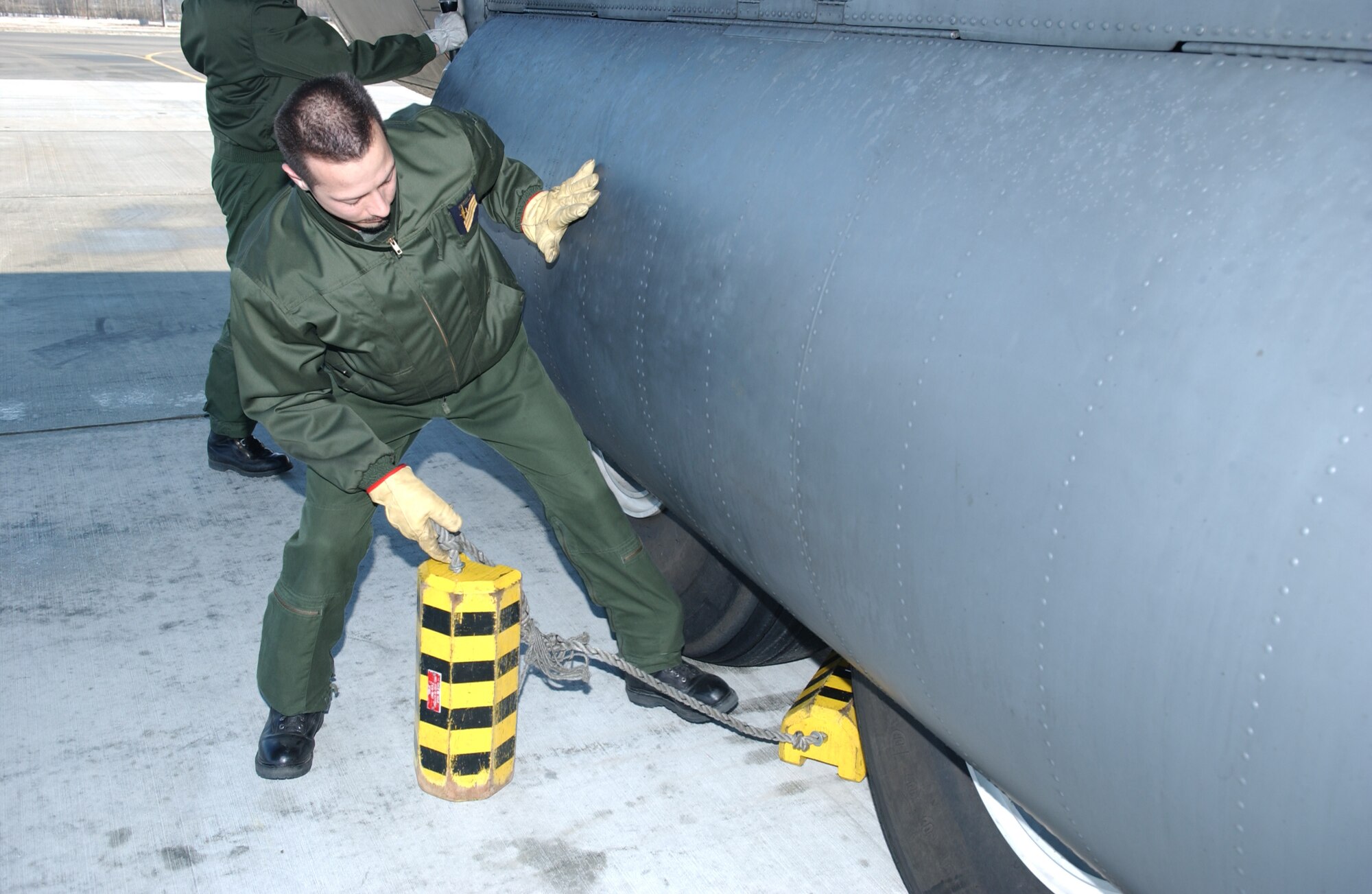 EIELSON AIR FORCE BASE, Alaska -- Master Sgt. Orieux, French Air Force flight engineer, removes the chocks from a C-130 prior to take off on April 13 during Red Flag-Alaska 07-1. Red Flag-Alaska is a Pacific Air Forces-directed field training exercise for U.S. forces flown under simulated air combat conditions. It is conducted on the Pacific Alaskan Range Complex with air operations flown out of Eielson and Elmendorf Air Force Bases. (U.S. Air Force Photo by Airman 1st Class Jonathan Snyder)