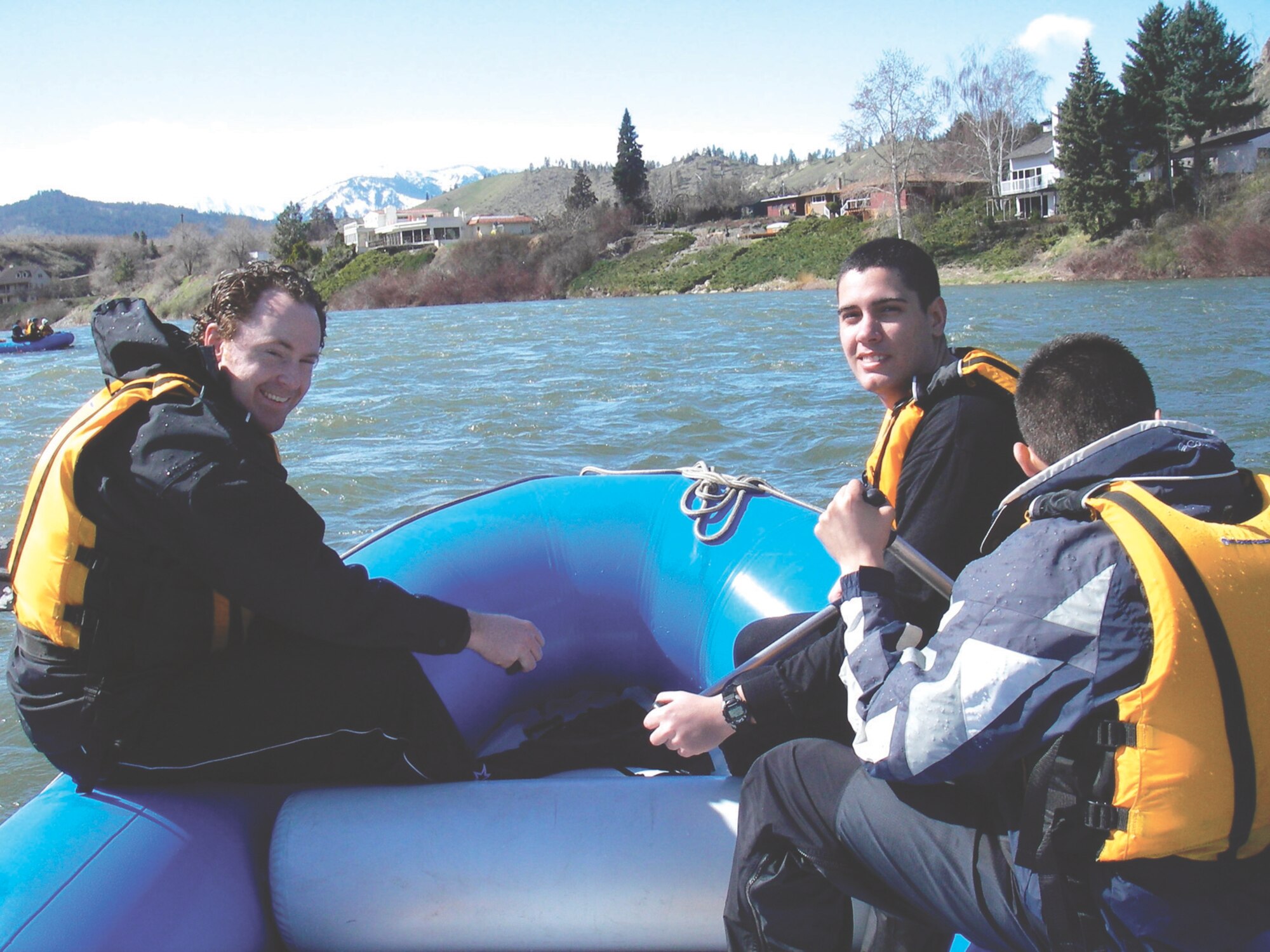 MCCHORD AIR FORCE BASE, Wash. -- Tyler Hemstreet, 62nd Airlift Wing, left, and Airman 1st Class Nelson Lopez-Toledo, 62nd Services Squadron, center, take a minute to catch their breath after navigating the Wenatchee River, while Airman Miguel Millares-Chavez, 62nd SVS, continues to row during a recent Adventures Unlimited rafting trip.