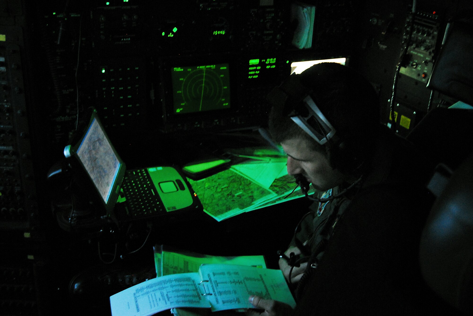 Capt. Justin Davis, 71st Rescue Squadron HC-130P navigator, relays a piece of threat information to the other members of his crew during a night training mission here April 10. Navigators perform a vital role during rescue missions, operating radar and infrared sensors along with precise mapping software to find a safe route through mountains while avoiding enemy threats.   (U.S. Air Force photo by Tech. Sgt. Parker Gyokeres)