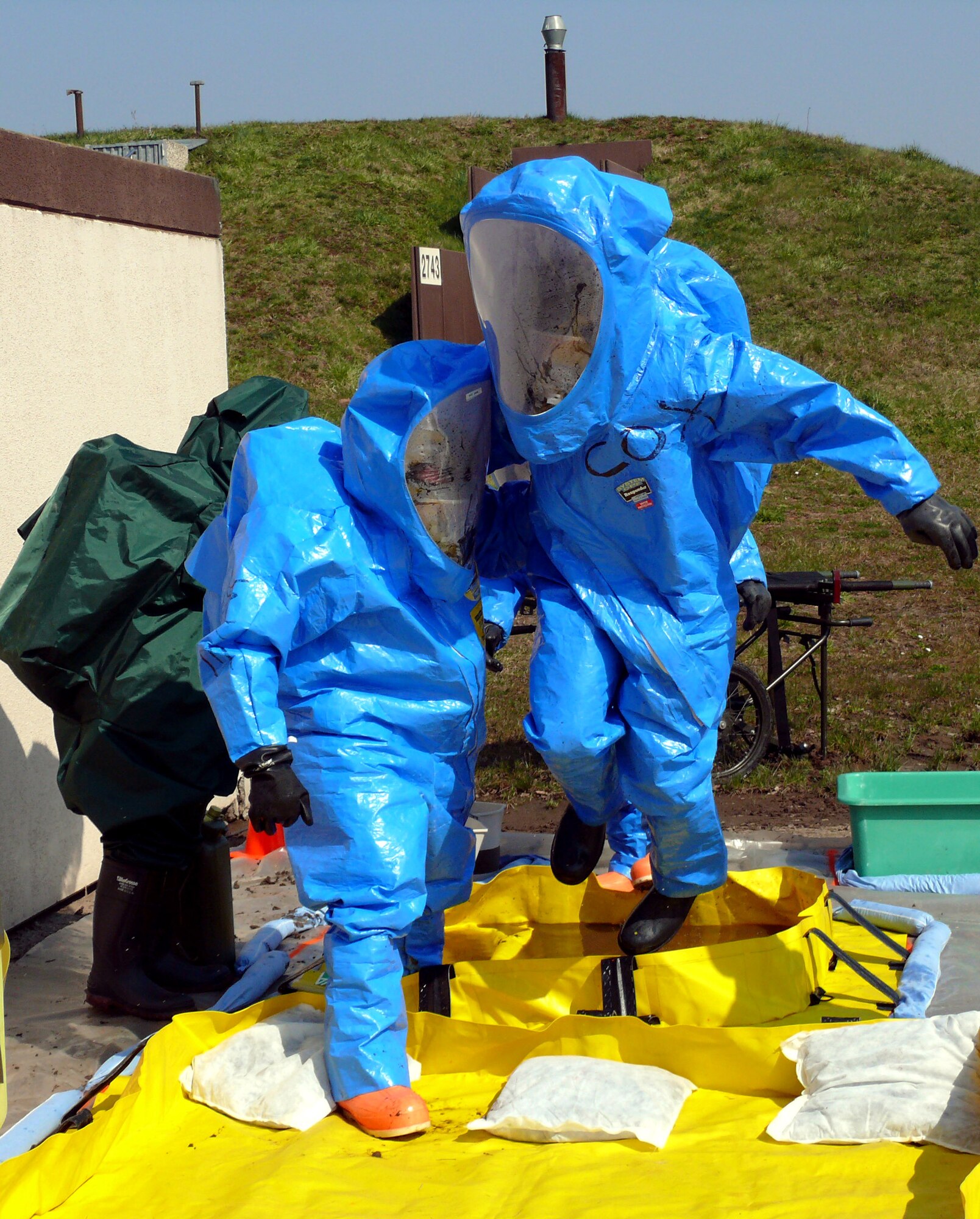 An Airman and a Soldier jump into a tub of cleaning solution during training, after entering a bunker housing a simulated chemical weapons lab April 12 at Ramstein Air Base, Germany. Responders from the Army and Air Force are training together at a chemical response exercise so they can respond as a single unit if needed. (U.S. Air Force photo)


