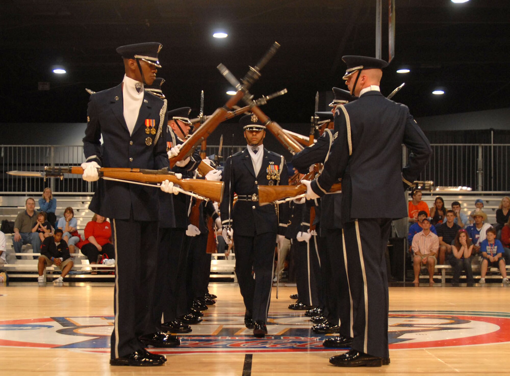 ATLANTA, Ga. -- First Lt. Joshua Hawkins walks through the spinning rifles of the Air Force Honor Guard Drill Team during their performance at Hoop City, an event surrounding the NCAA Final Four, April 1.  The Air Force Honor Guard Drill Team was invited to perform for various ceremonies associated with the NCAA Final Four events March 31 - April 2, including the opening ceremonies at Centennial Olympic Park March 31.